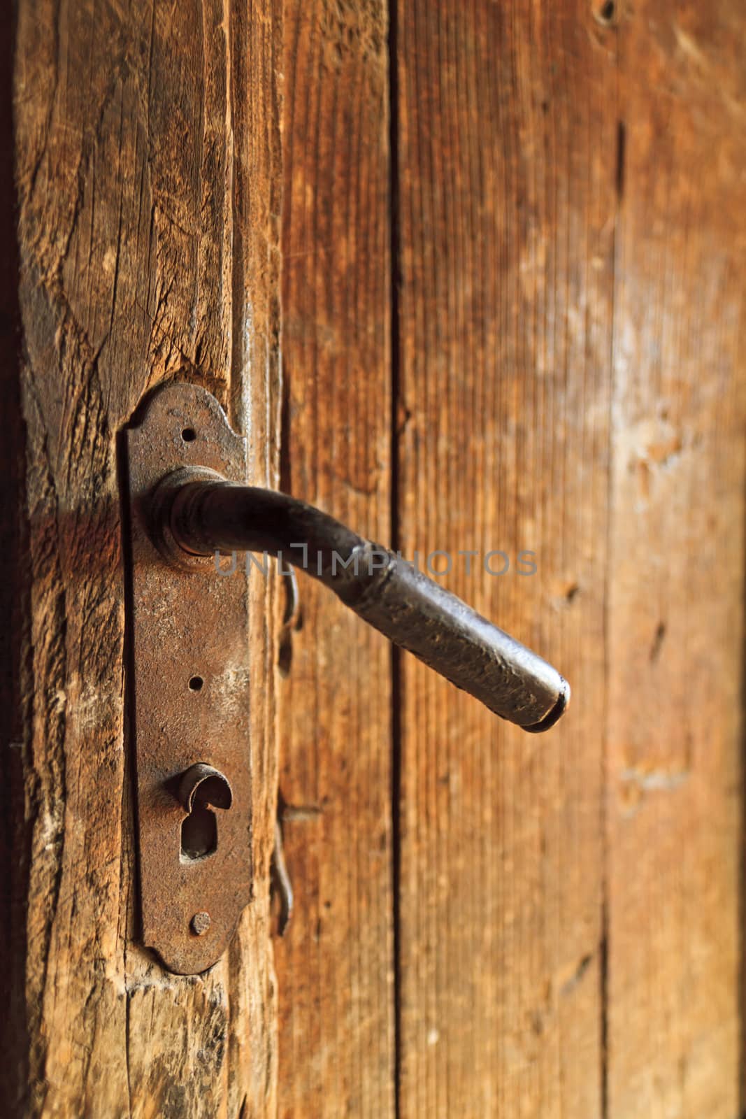 A century old rusty door knob on old wooden door