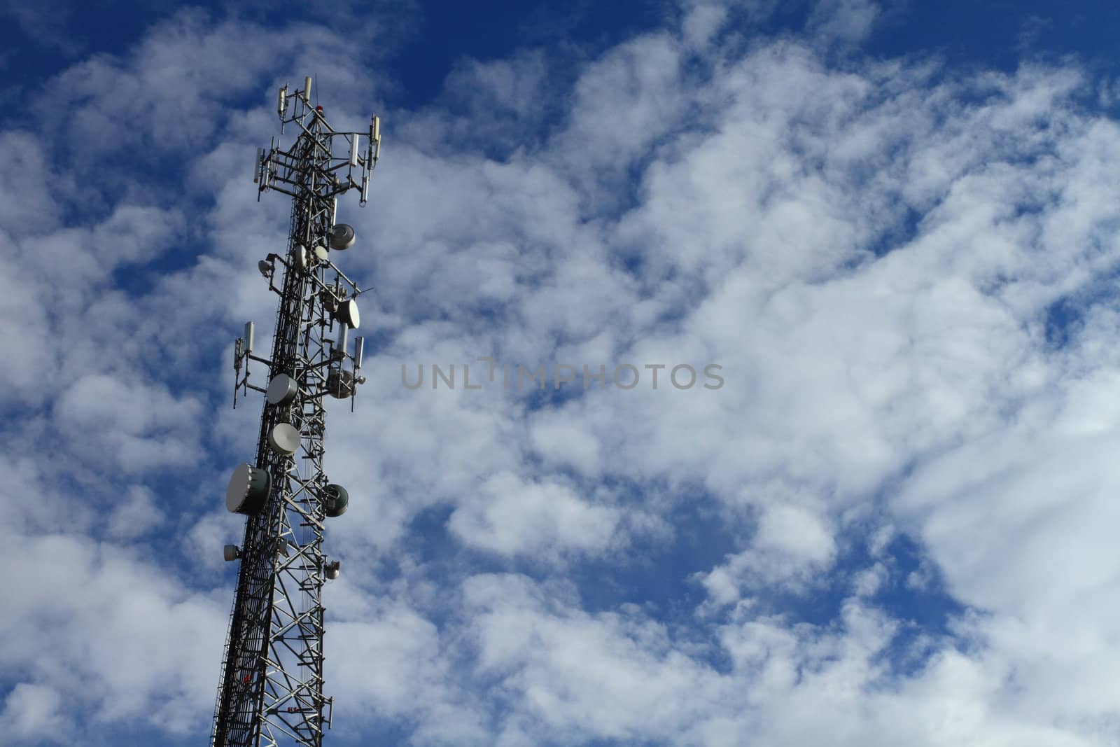Large telecommunication tower with dramatic clouds in the sky