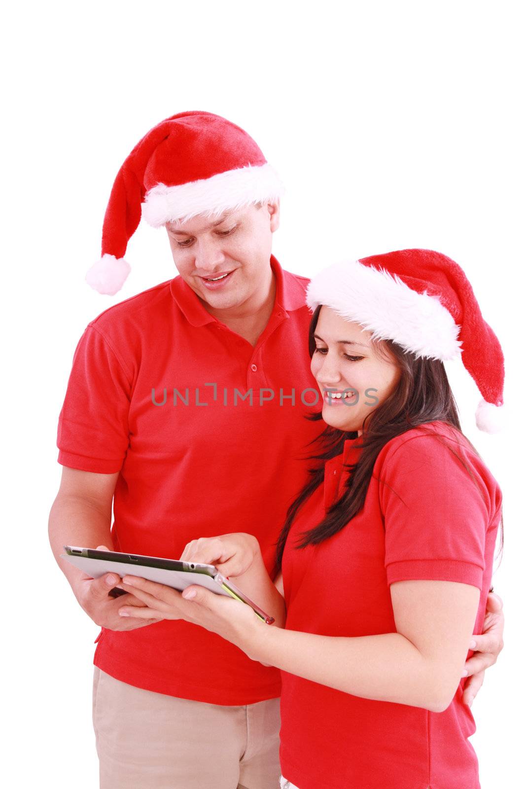 Happy Christmas couple looking a tablet computer. Isolated on white background.