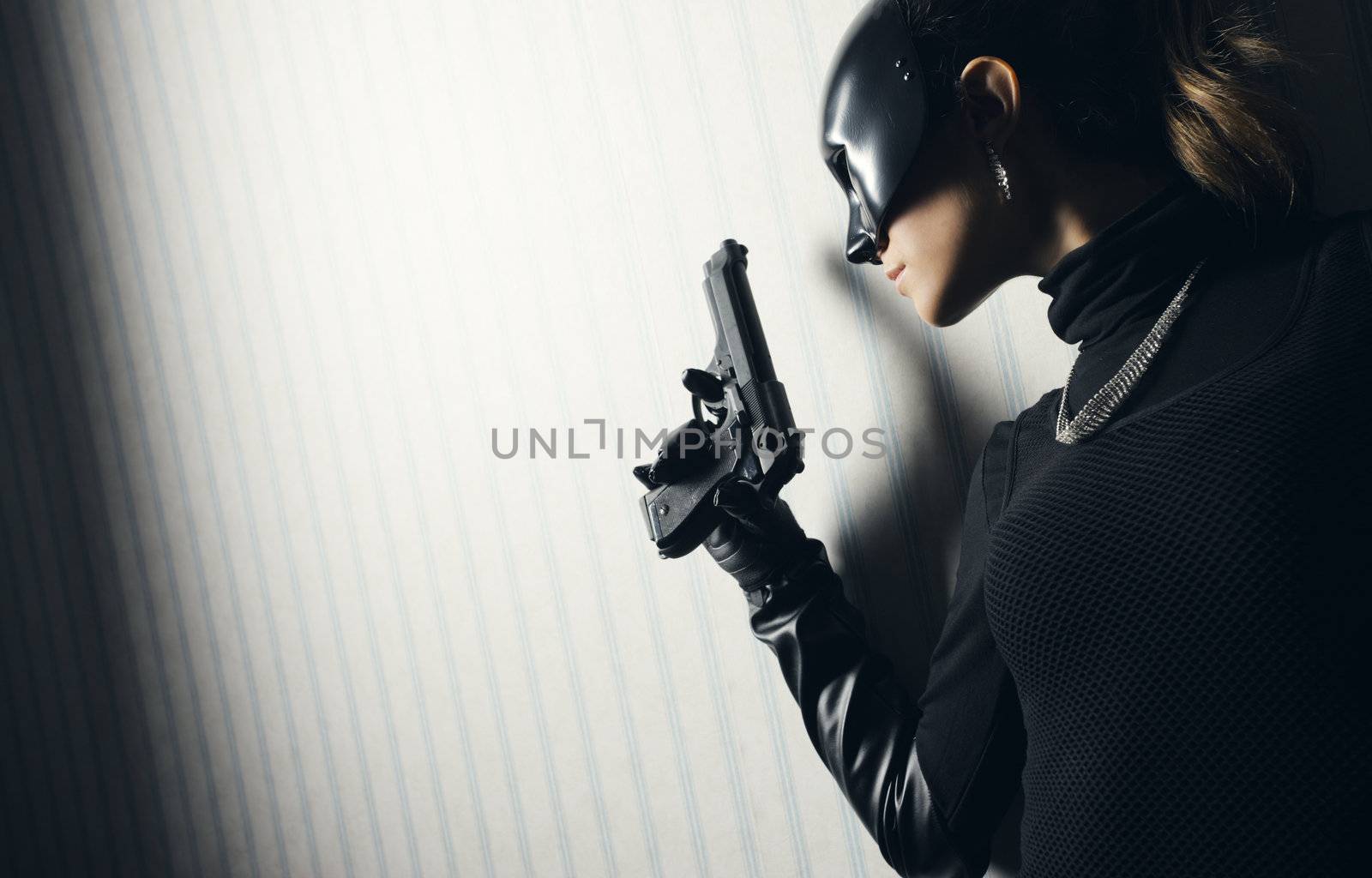 Female thief in black mask with gun