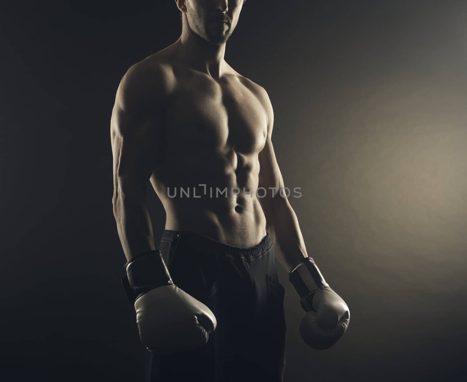 Male fighter posing in front of a dark background