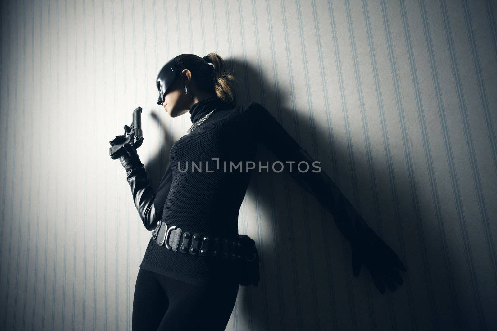 Female thief in black mask with gun