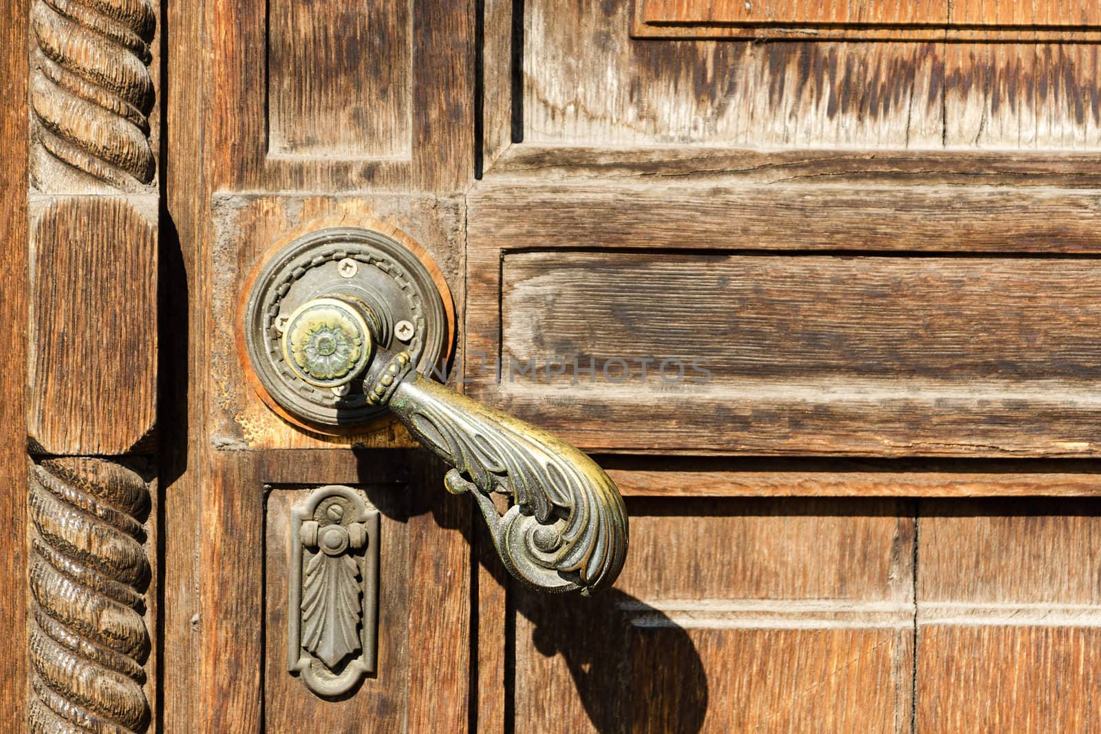 Vintage wooden door with a ornamental metal handle