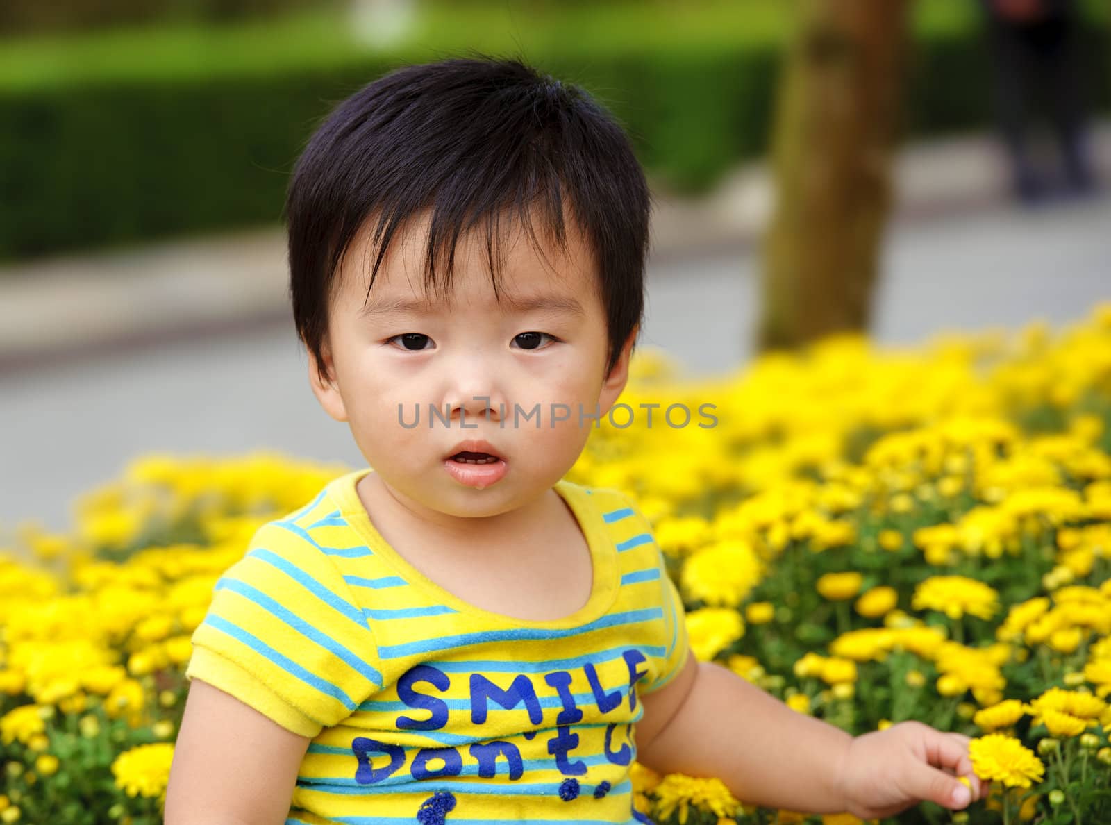 a cute baby is playing in garden by jackq
