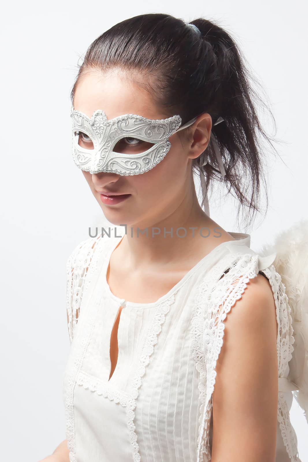 Young and beautiful girl in the mask and costume of an angel