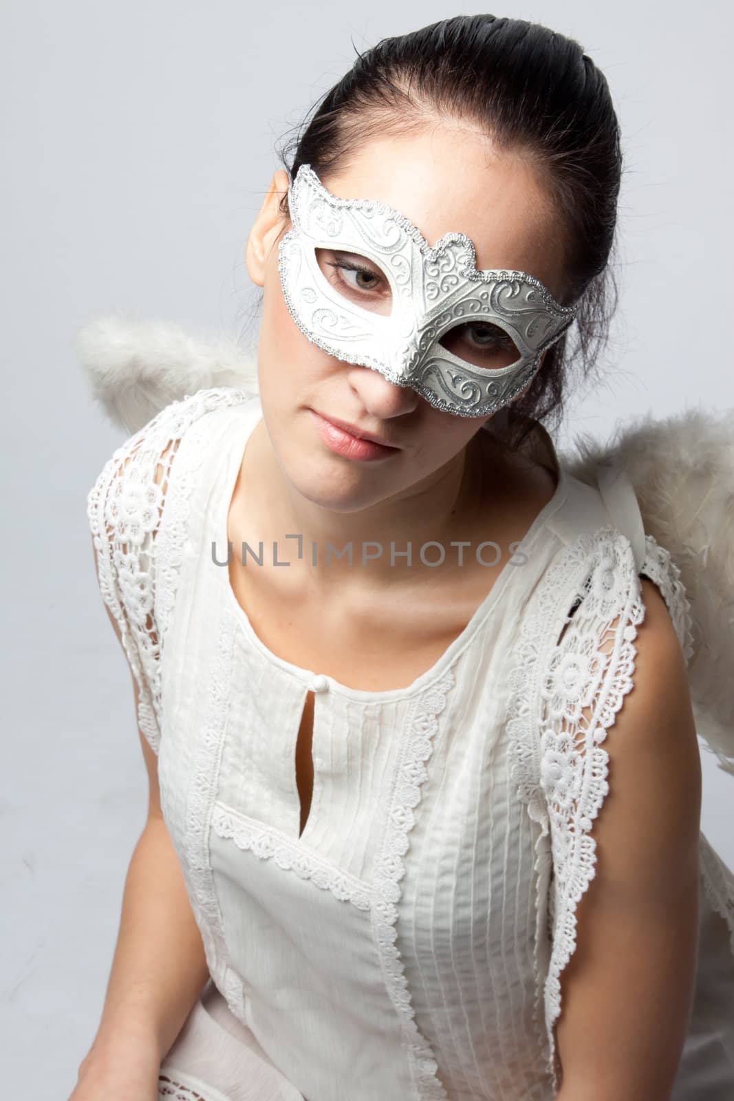 Young and beautiful girl in the mask and costume of an angel