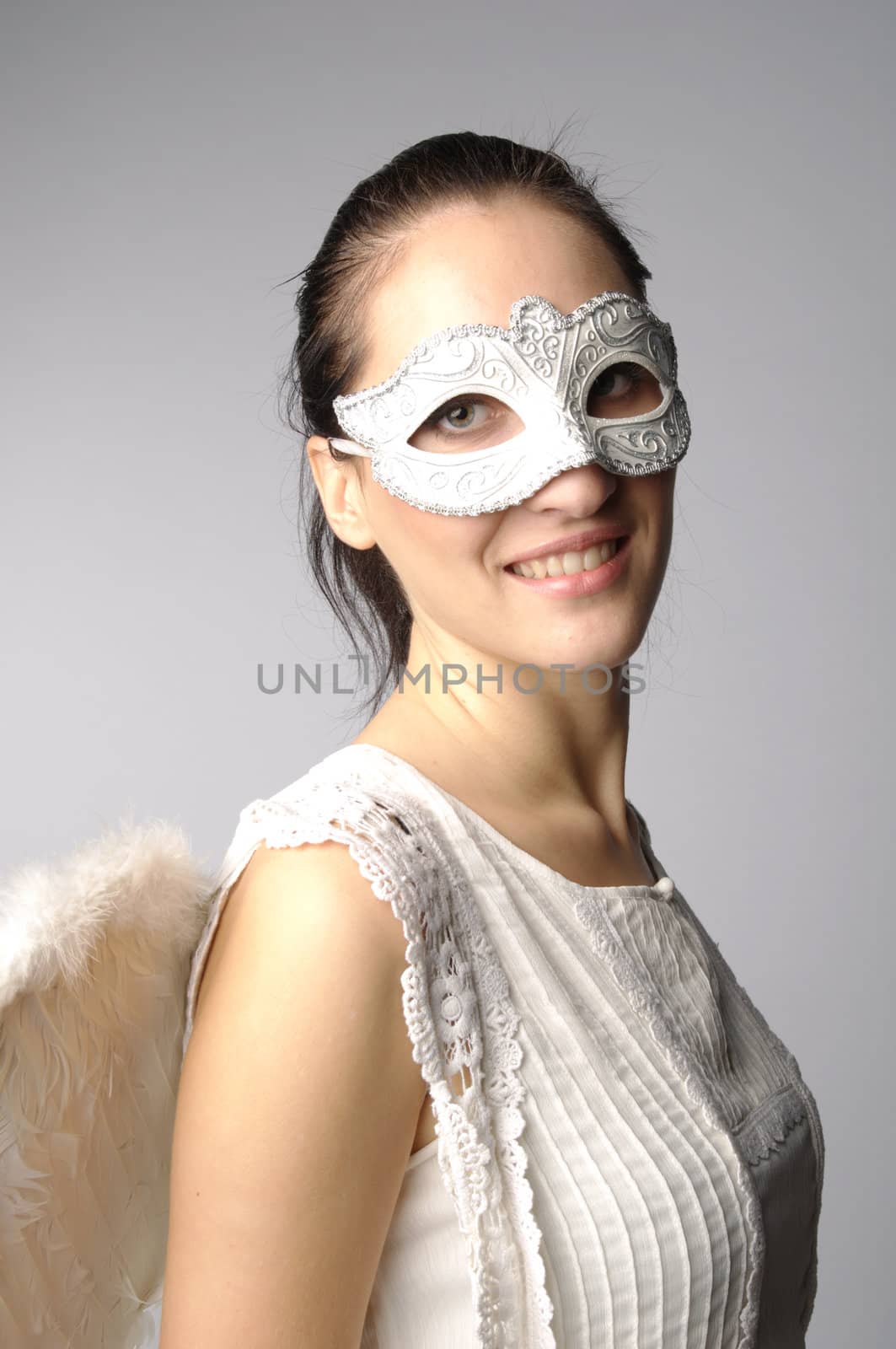 Young and beautiful girl in the mask and costume of an angel