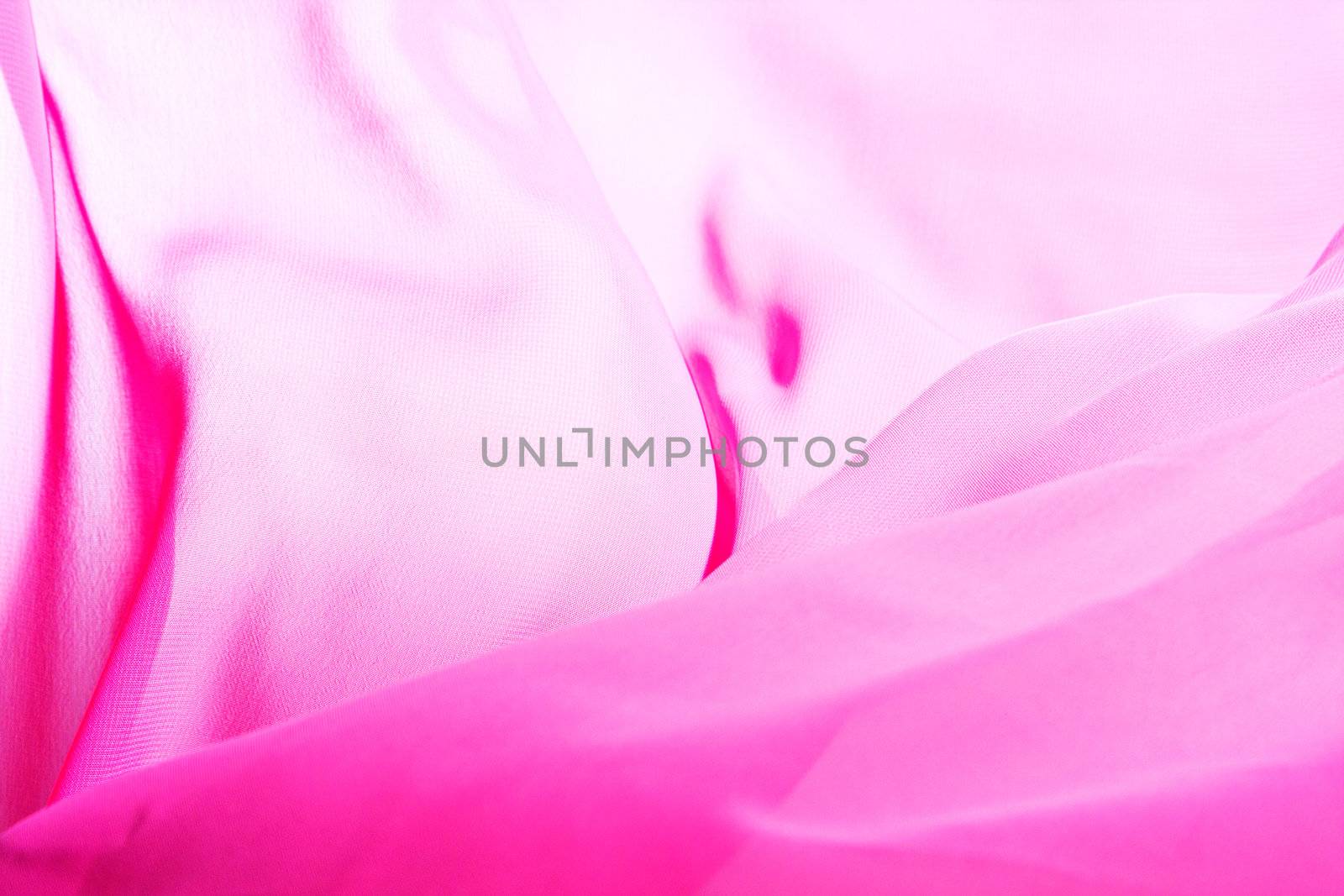 Pink fabric winds waves, creating a beautiful background of the folds