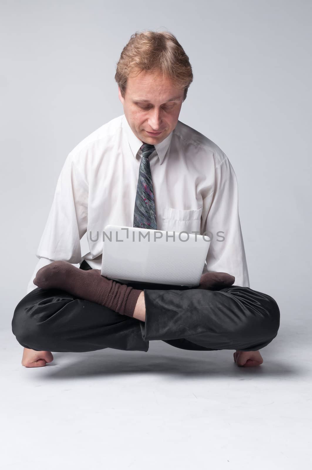Young businessman yoga before an open notebook