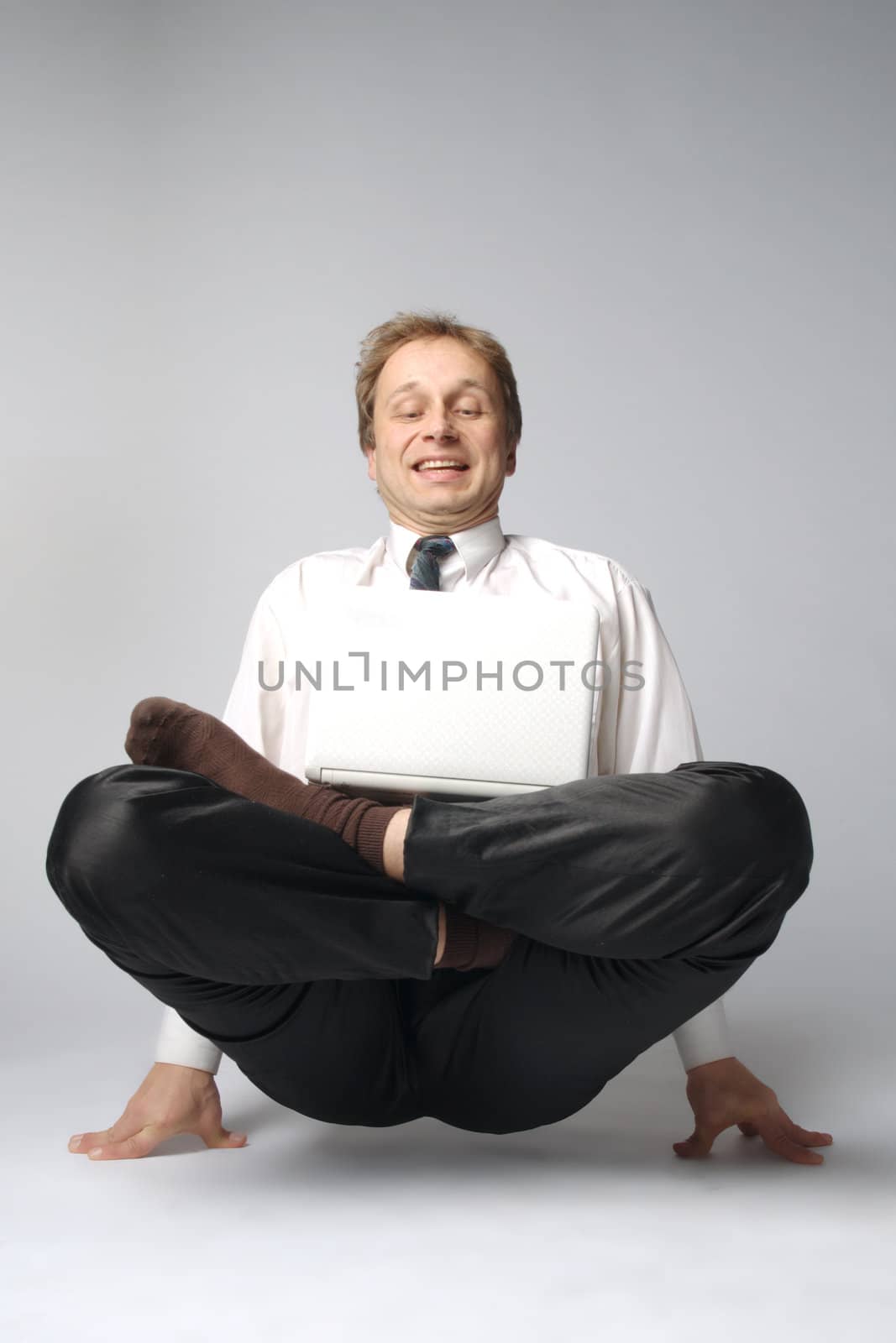Young businessman yoga before an open notebook