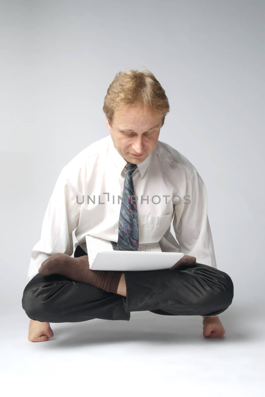 Young businessman yoga before an open notebook