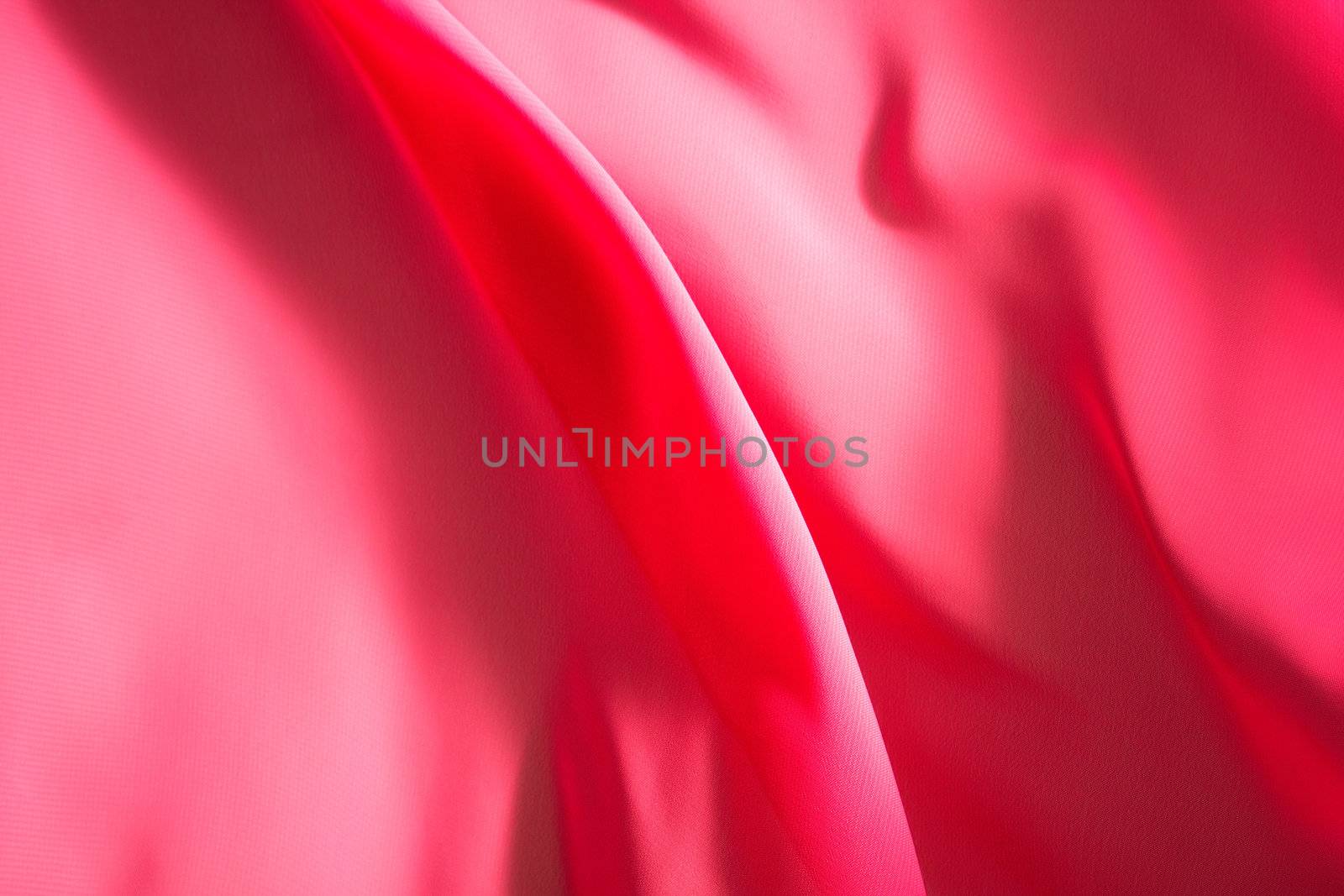 Pink fabric winds waves, creating a beautiful background of the folds