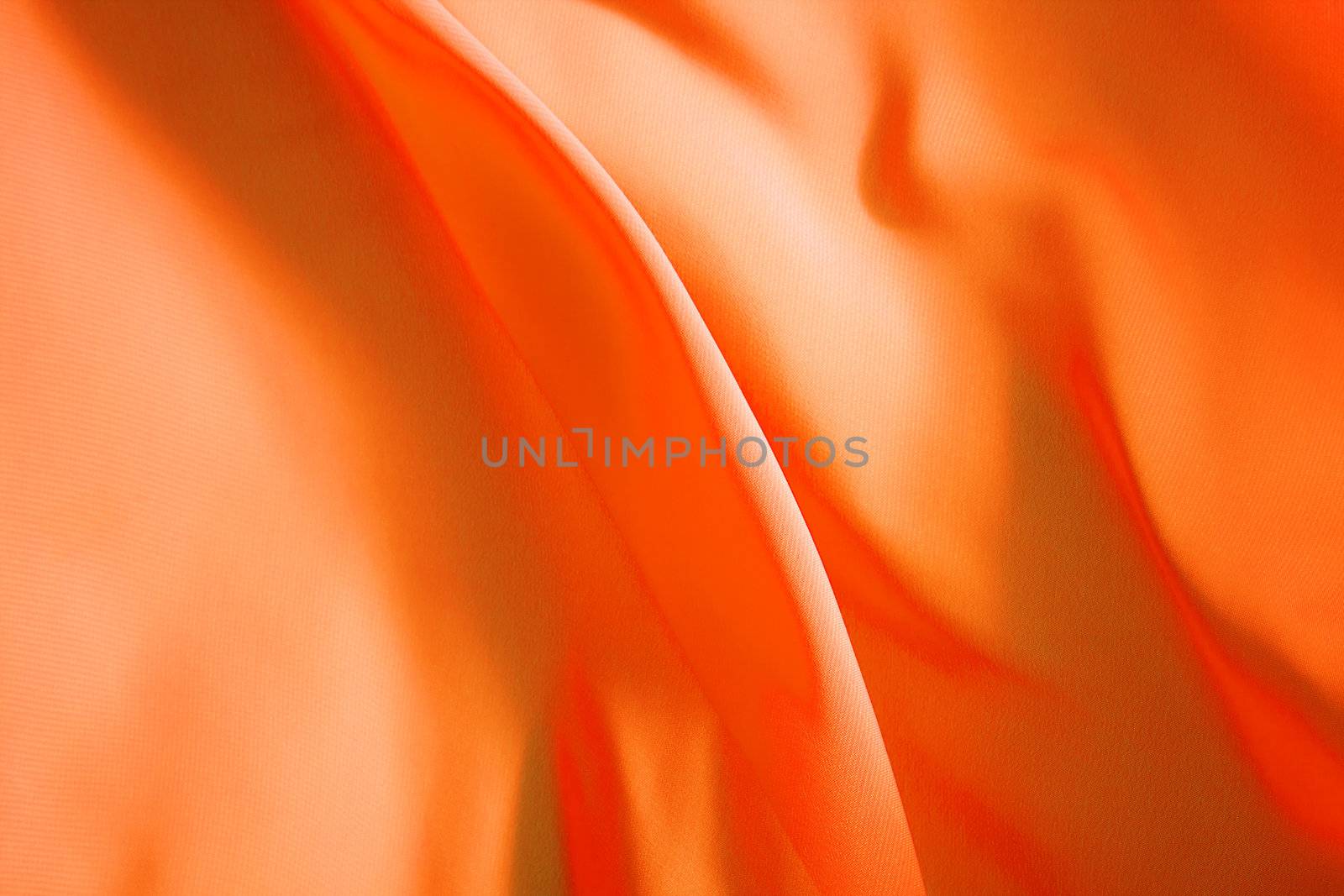 orange fabric winds waves, creating a beautiful background of the folds