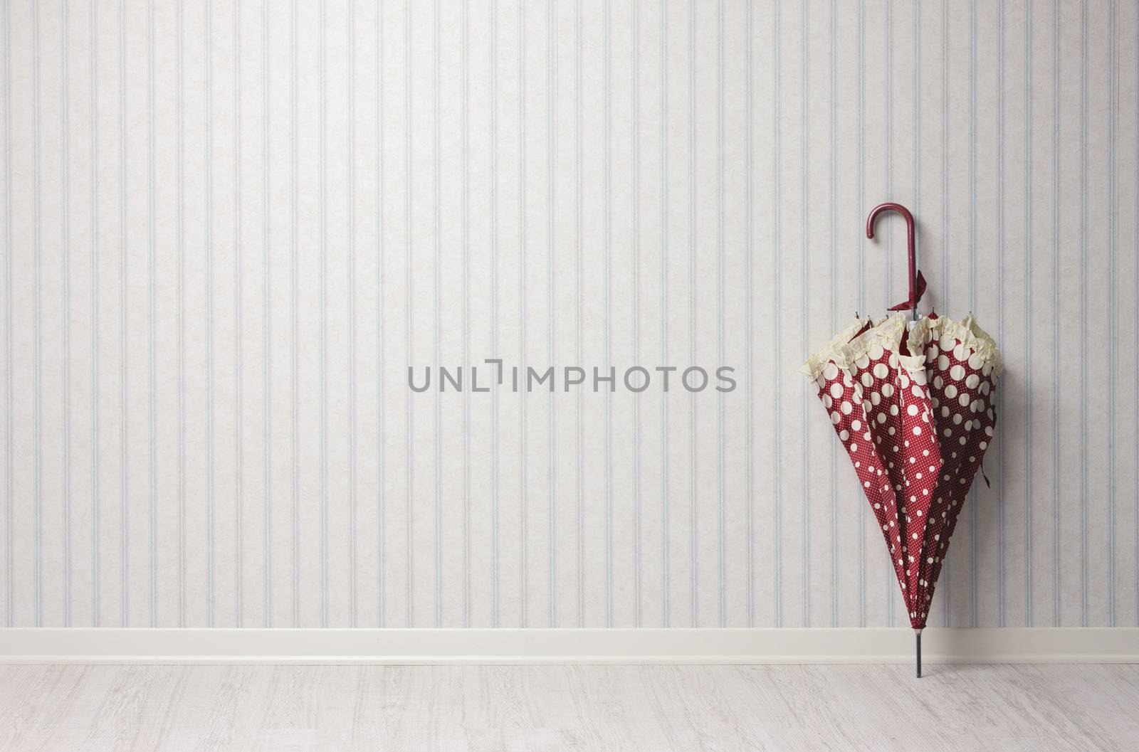 Umbrella in an empty room on vintage wallpaper