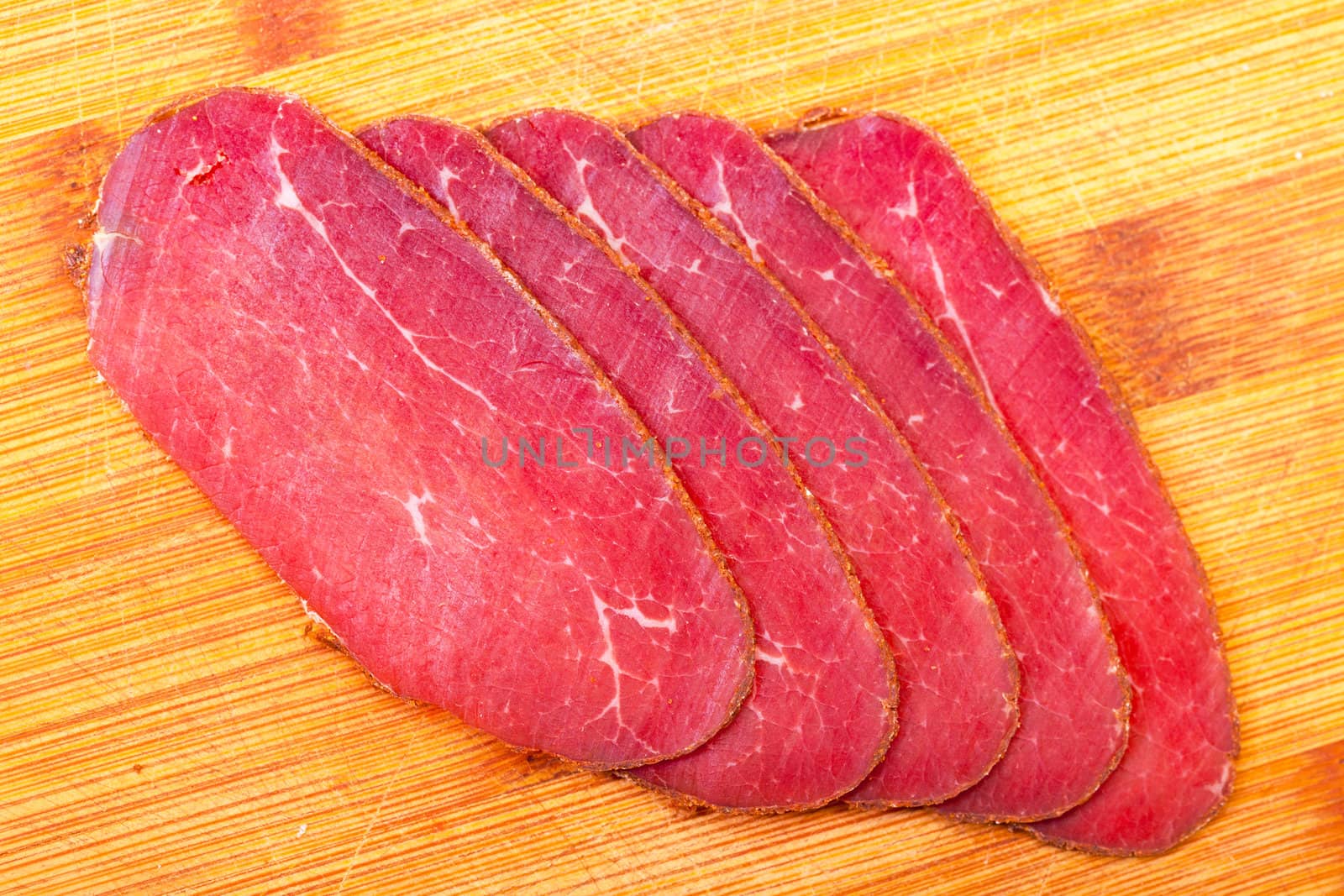 Slices of Smoked Meat, on wood background