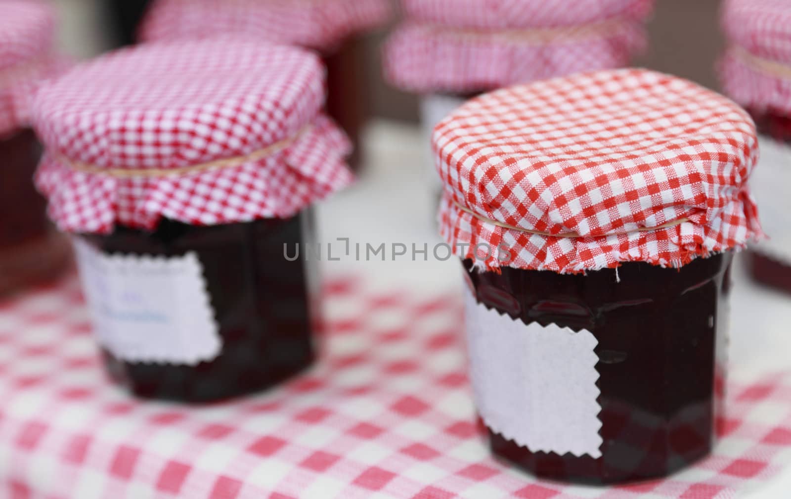 Image of jars of savoury old-fashined homemade jam on a table.
