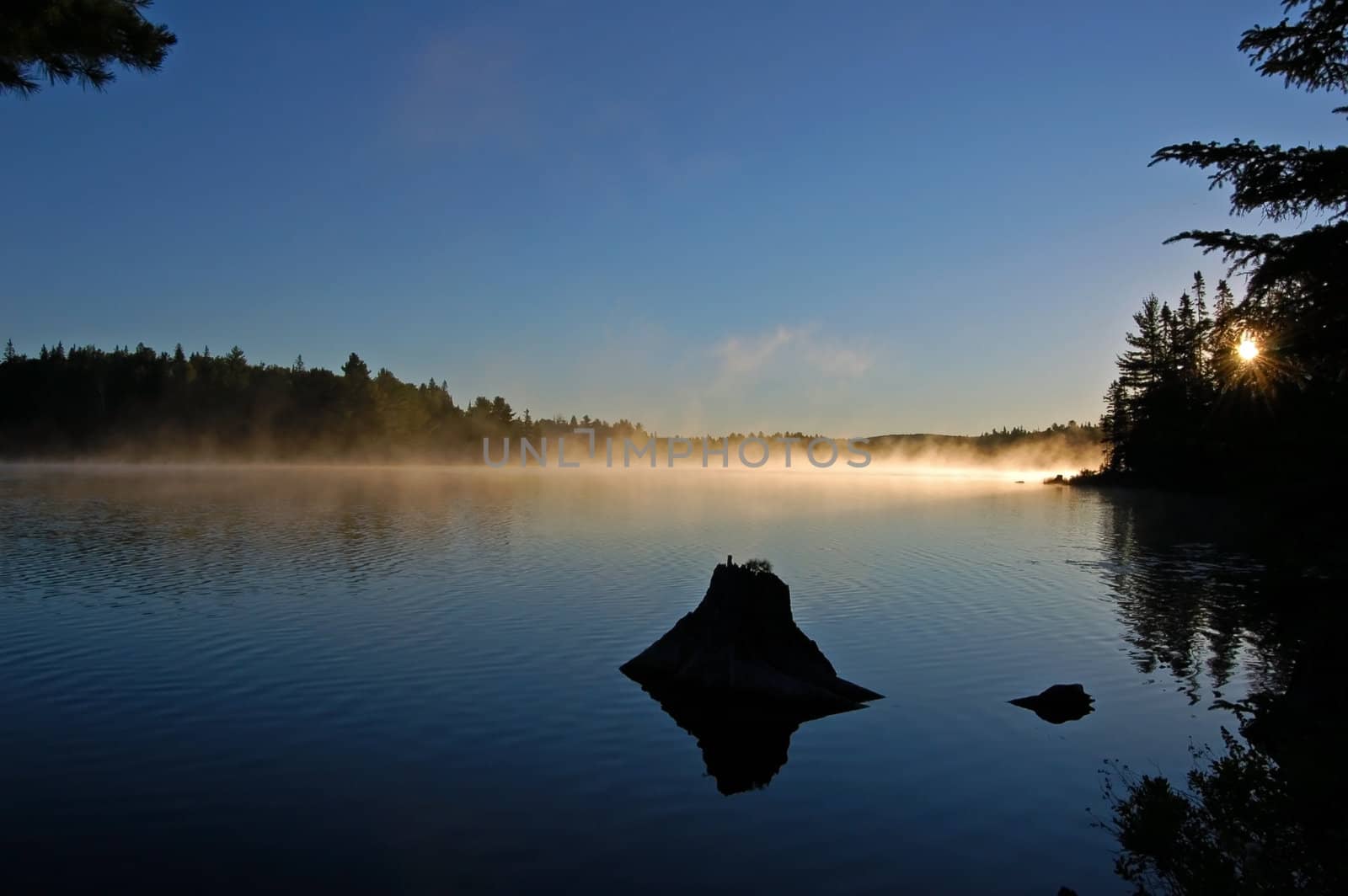 Sunrise and mist in beautiful lake in Algonquin Park