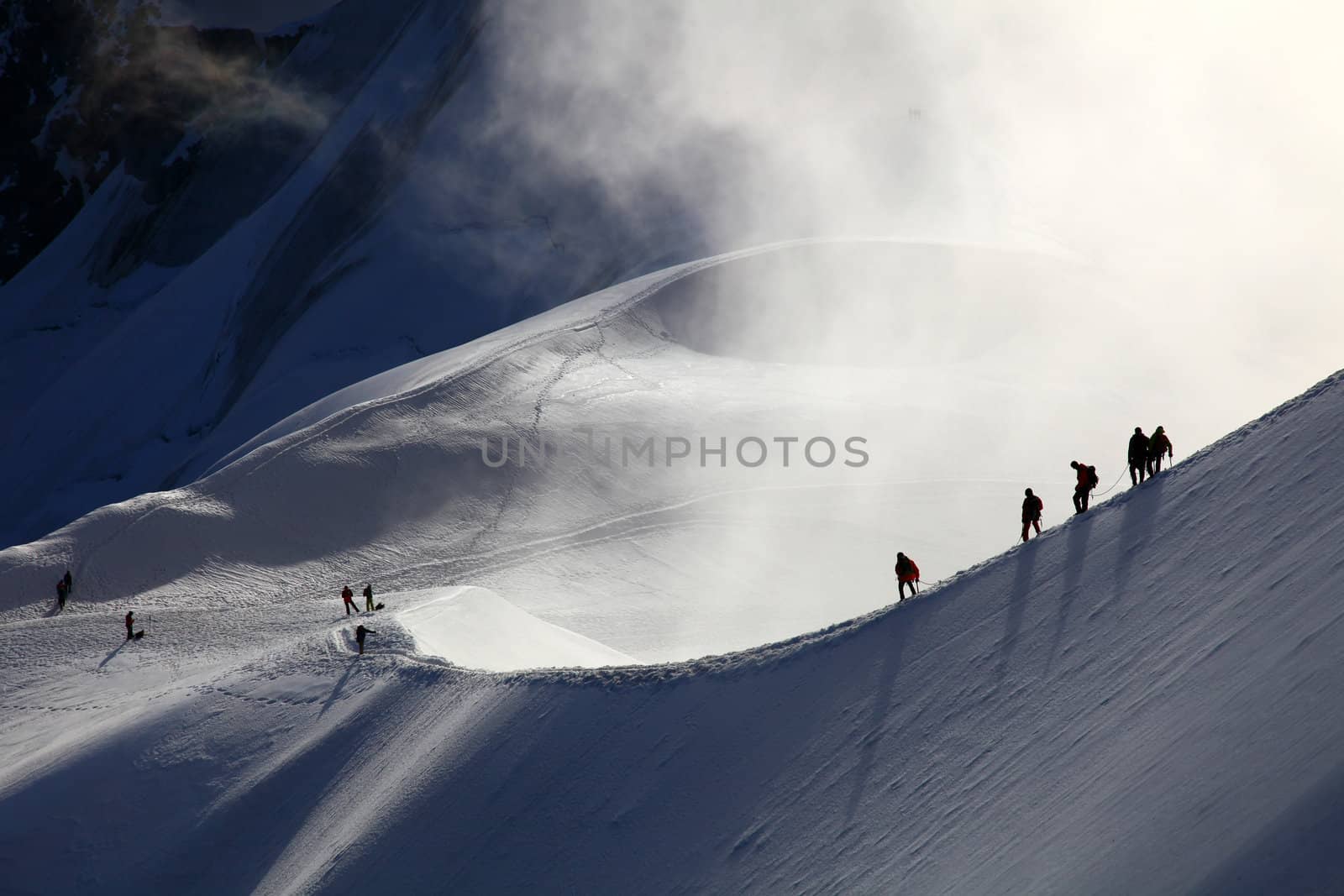 A group of alpinists on their way to the mont blanc at dawn.