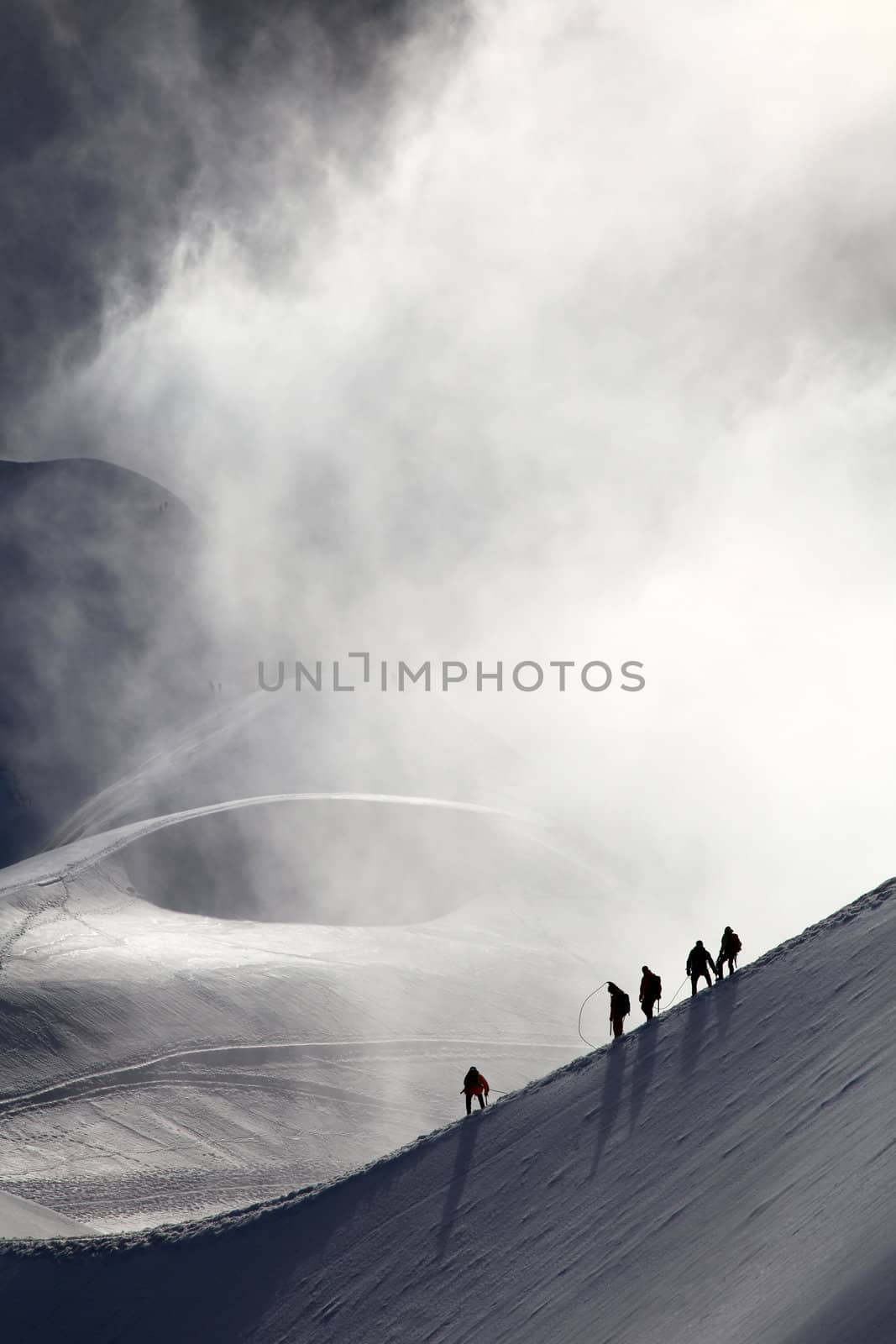 A group of alpinists on their way to the mont blanc at dawn.