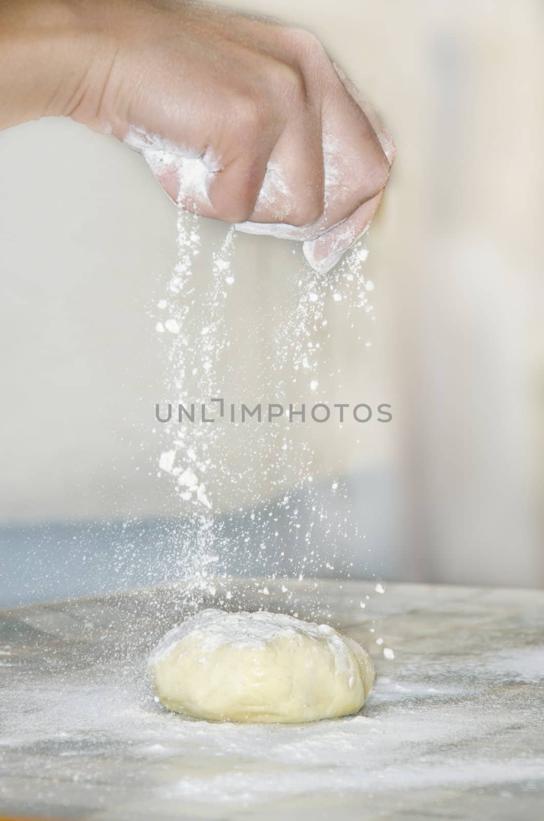 woman makes and prepares pastry in a bakery kitchen. Adding flour bits.