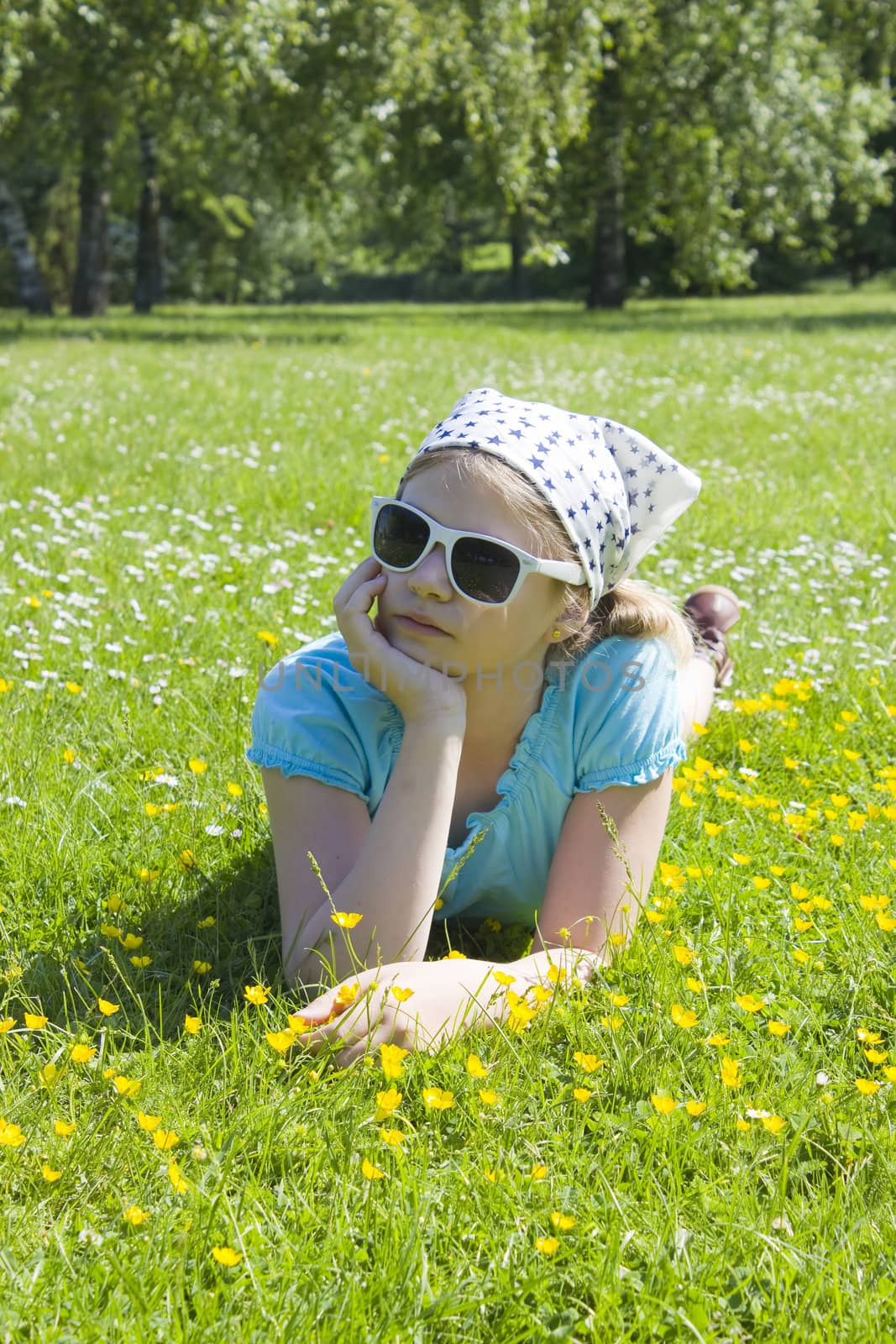 little girl lying on grass  by miradrozdowski