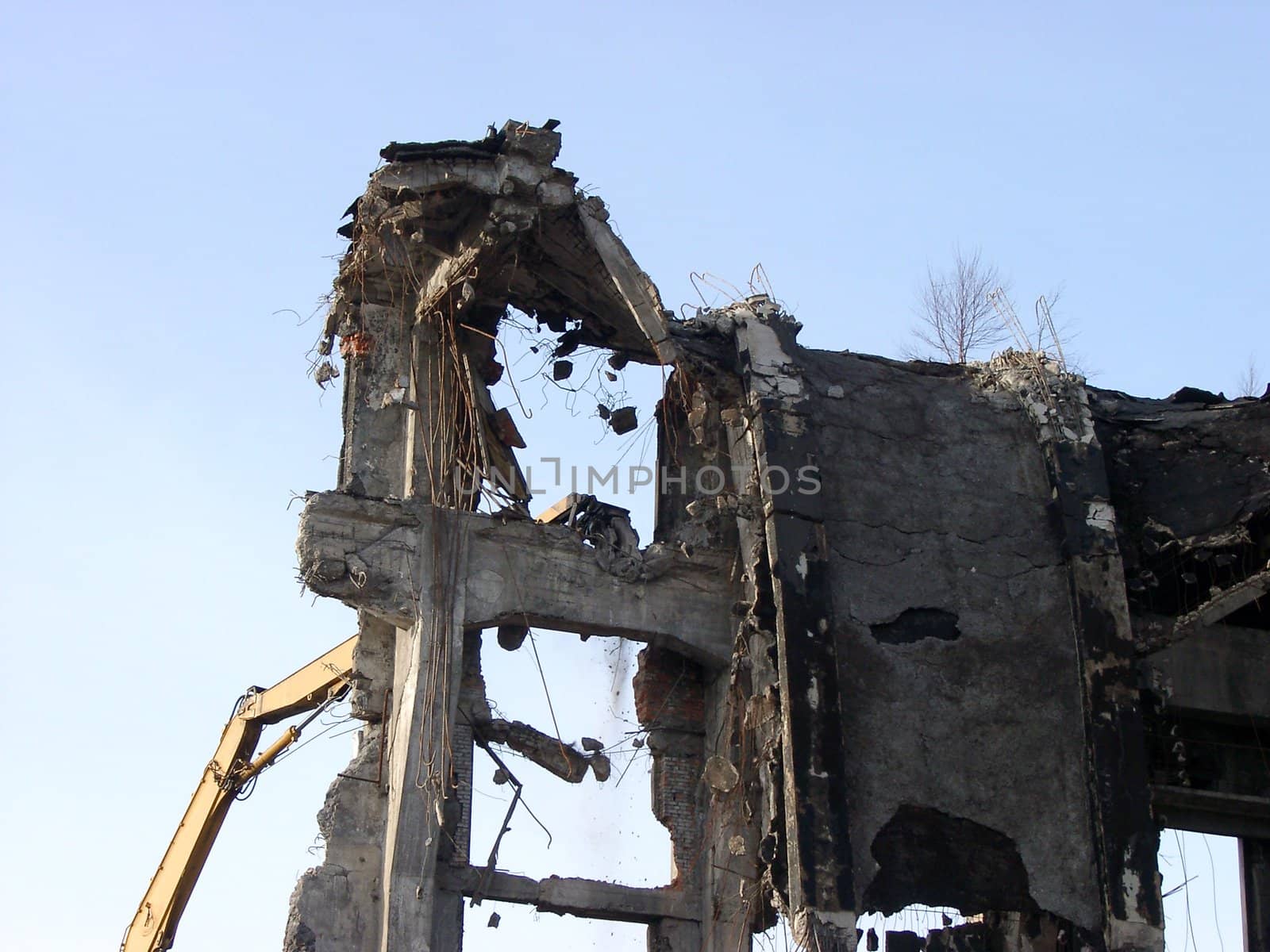 View of demolition works on high industrial building at sunny day.