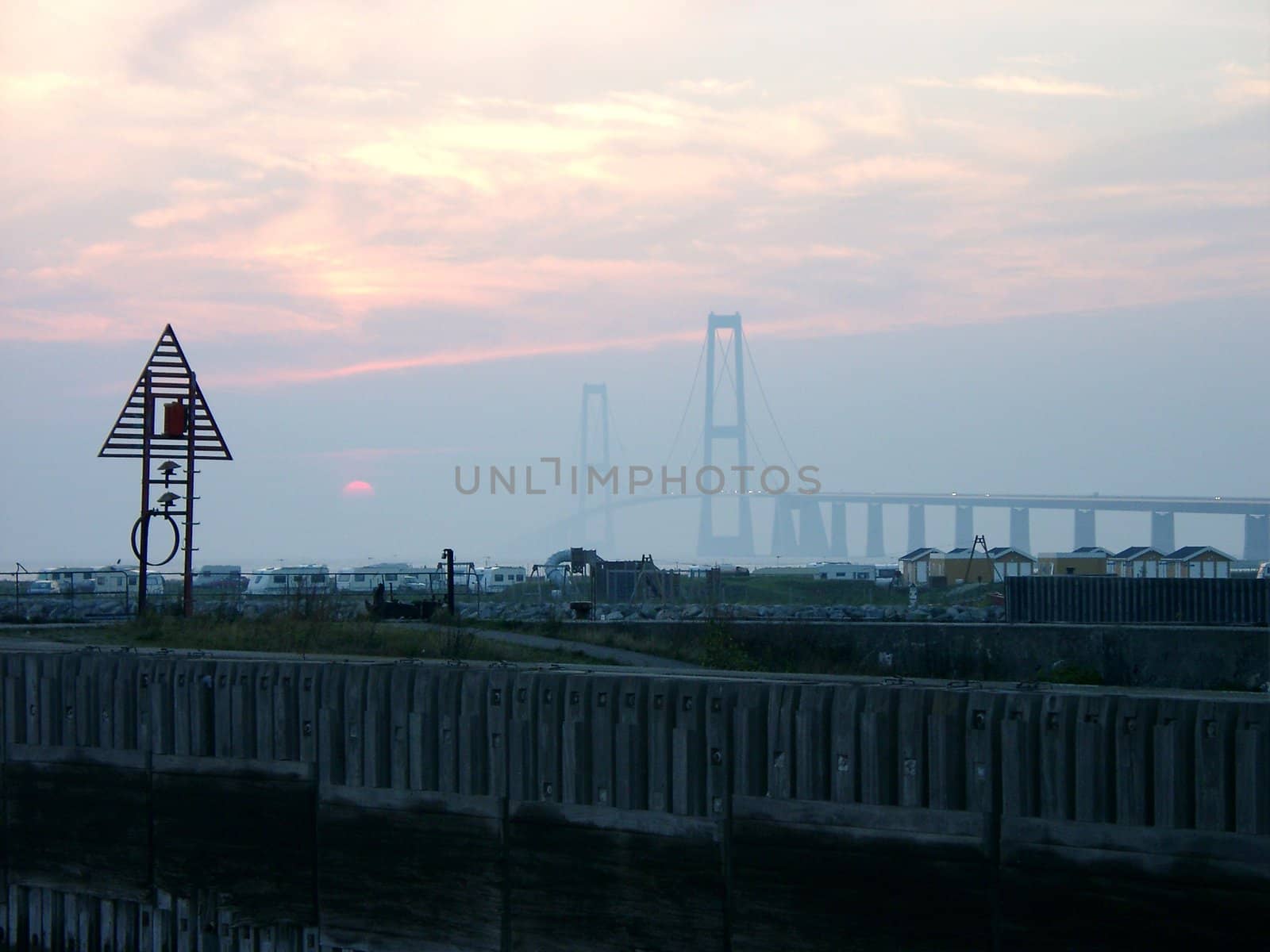 View of sunset over the camping near Storebelt Bridge in Denmark.