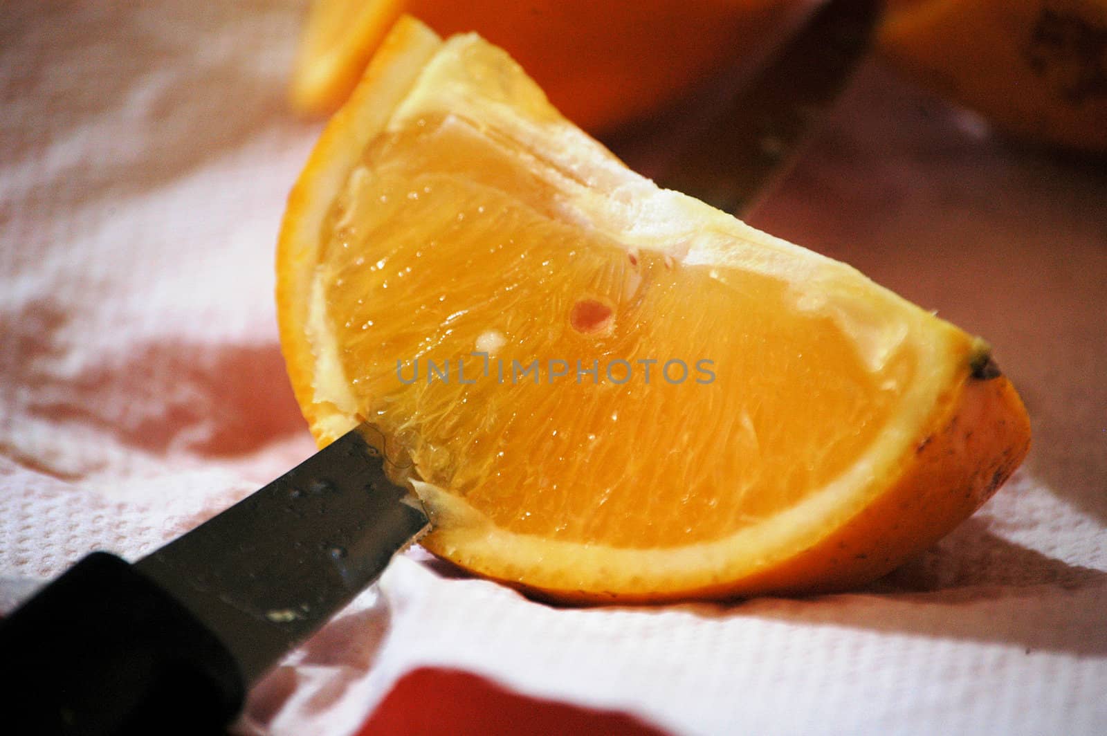 cutting an orange quarter so that it can be eaten