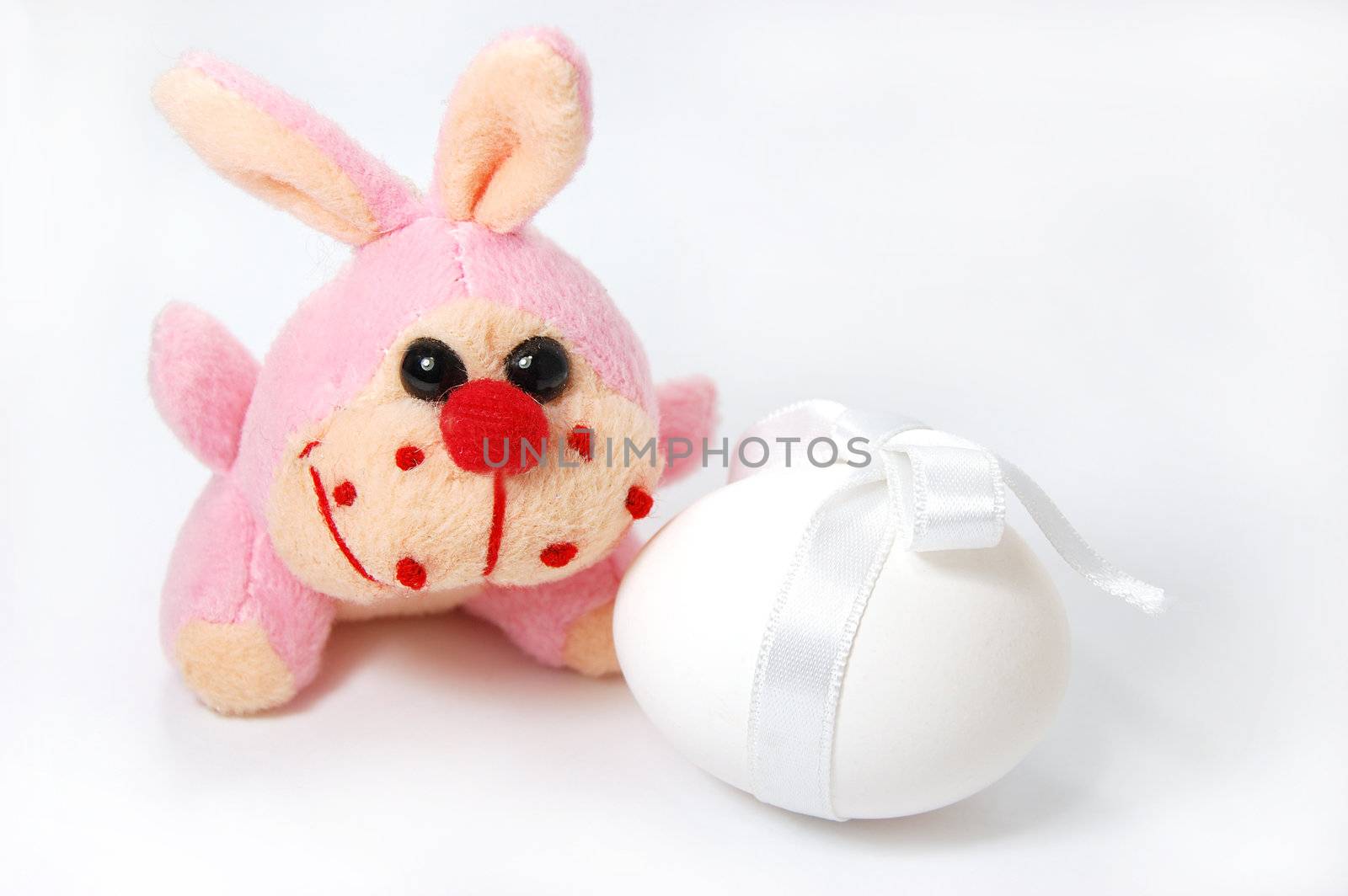 Toy bunny and white egg isolated on white