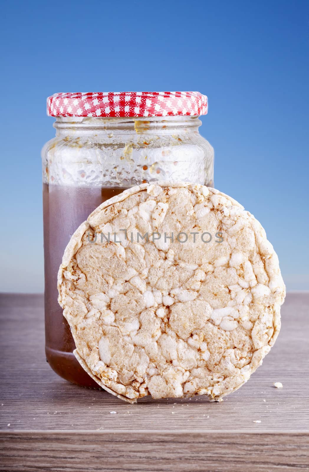 A rice toast laying over a jar of jam