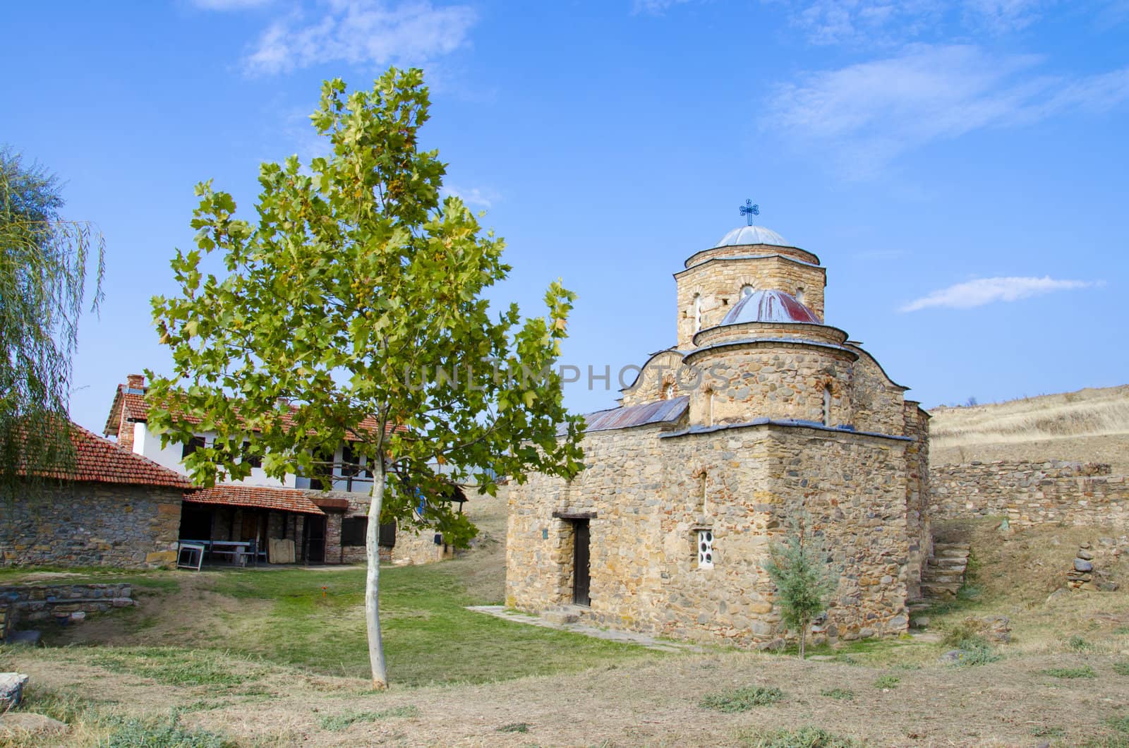 ancient church with green tree and blue sky. St. Nikola old church near ancient town ruins Bargala in Macedonia