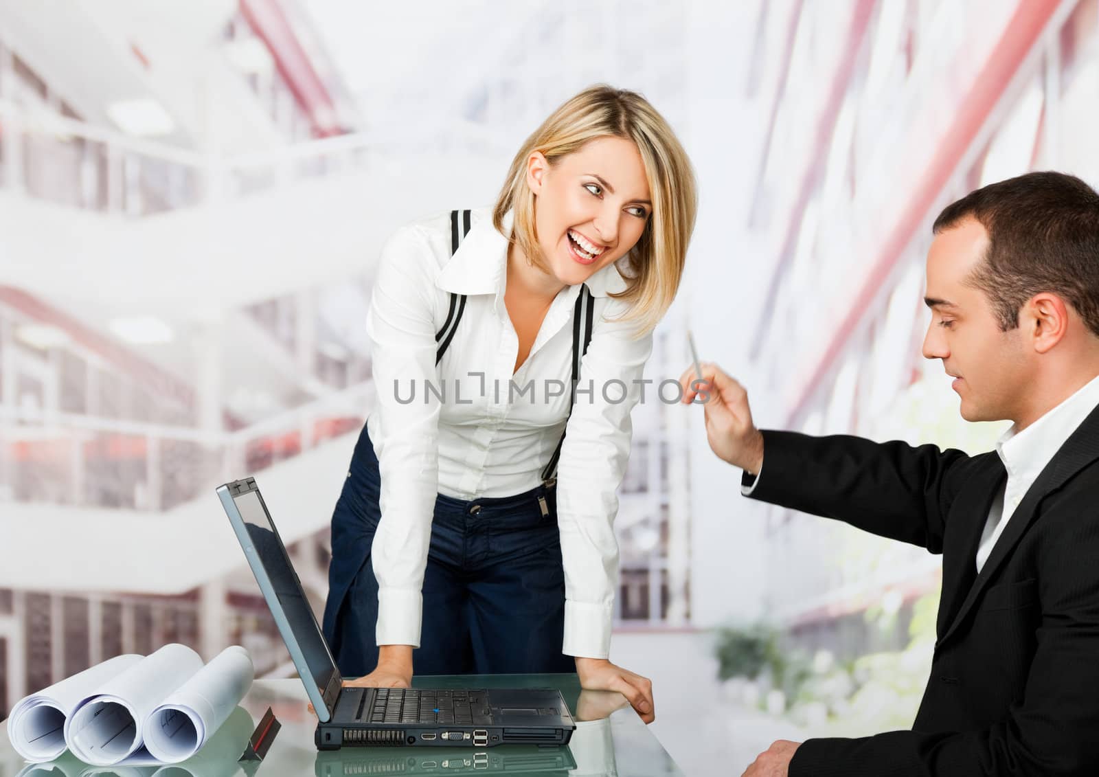Male and female architects working behind laptop - woman smiling