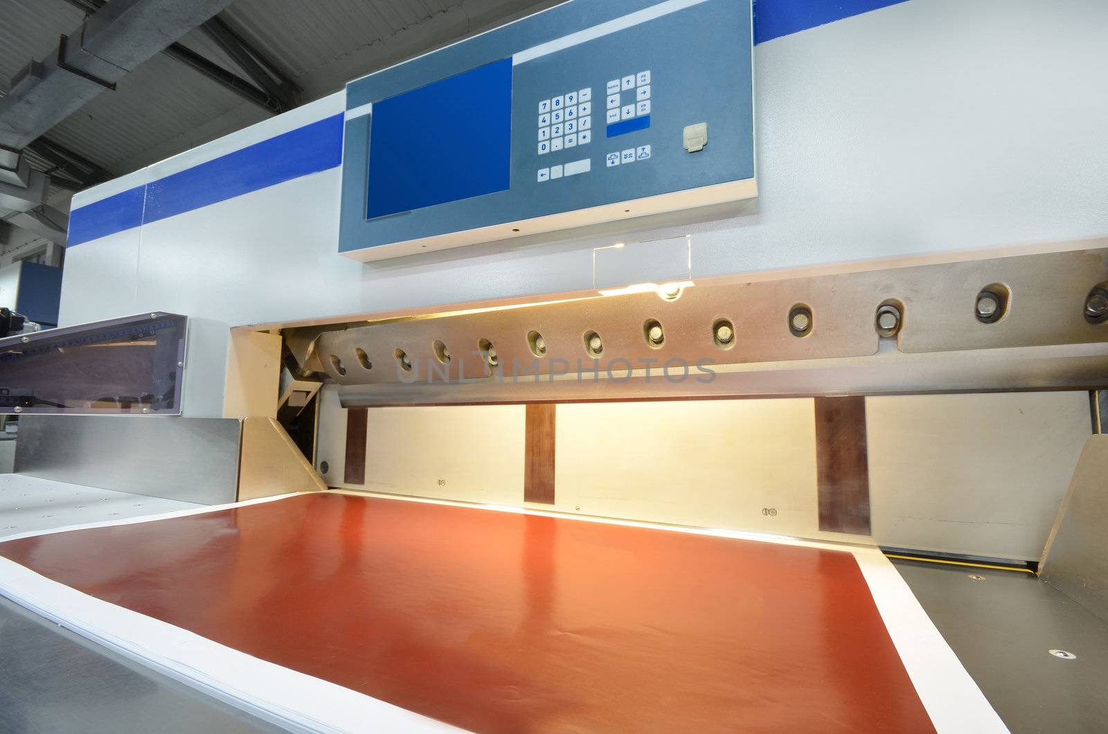 Front view of a modern paper guillotine with touch screen used in commercial printing industry (industrial knife cutter)