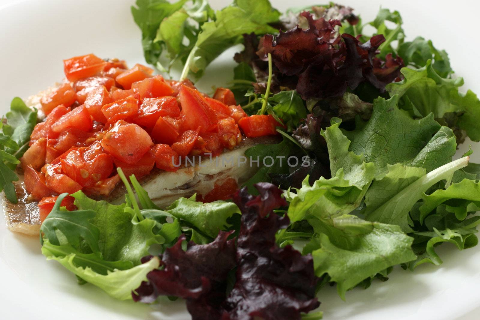 fried fish with cut tomato and salad by nataliamylova