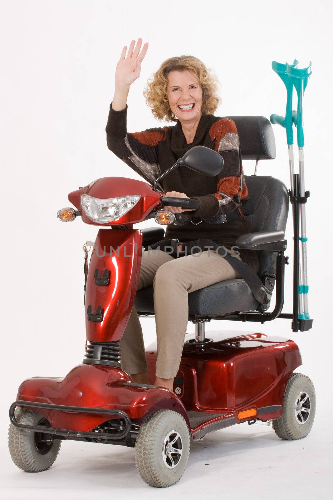 older women with disabilities sitting, waving on a scooter