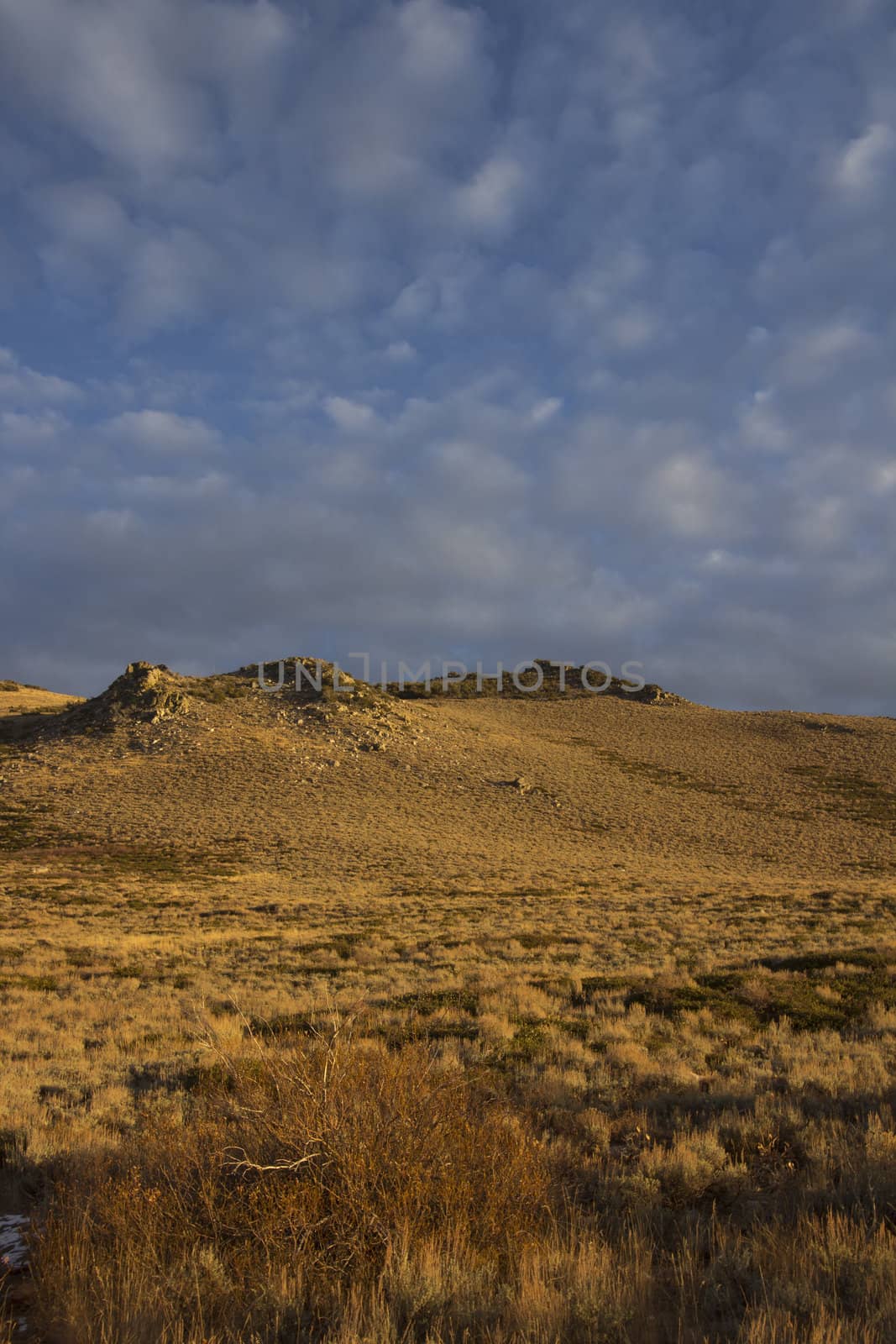 High desert sunset mountain with clouds by jeremywhat