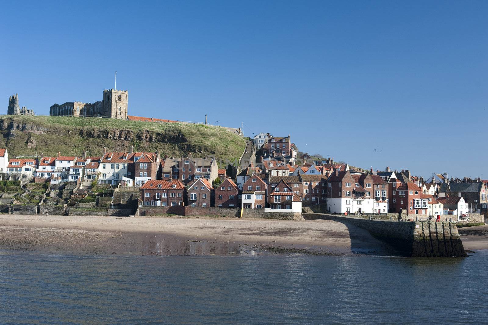 View of the waterfront and houses in Whitby in North Yorkshire with Tate hill in the background