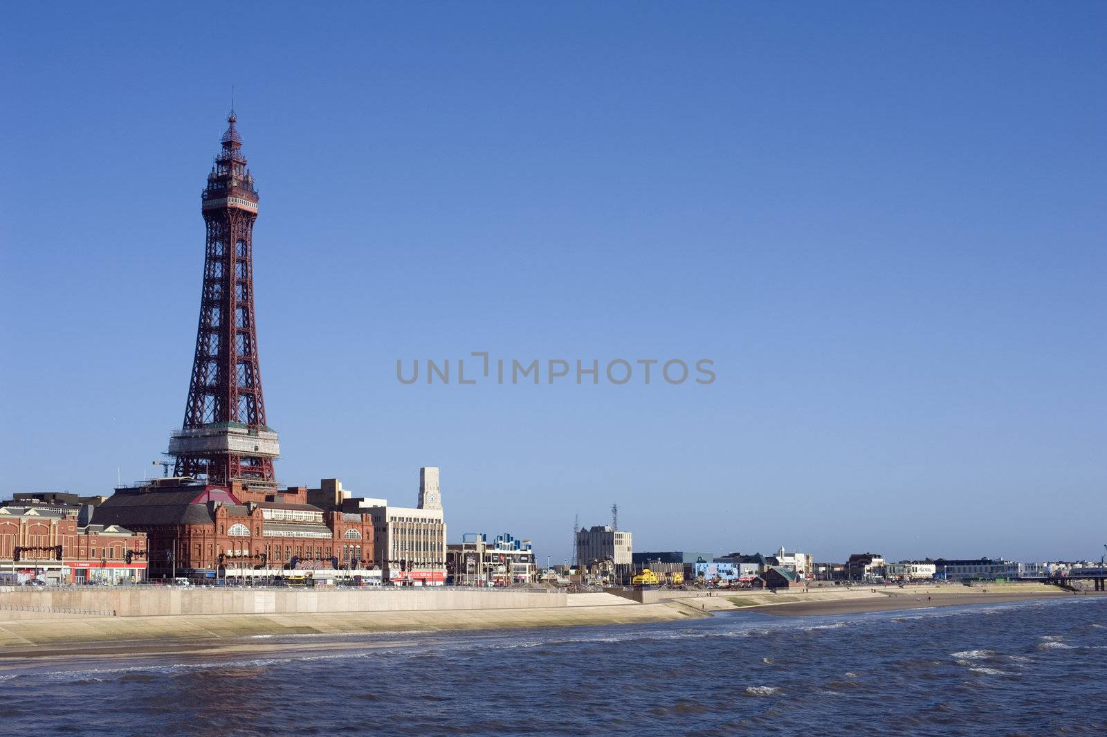 Blackpool waterfront and beach with Blackpool Tower, a historical Victorian lattice structure, overlooking the ocean