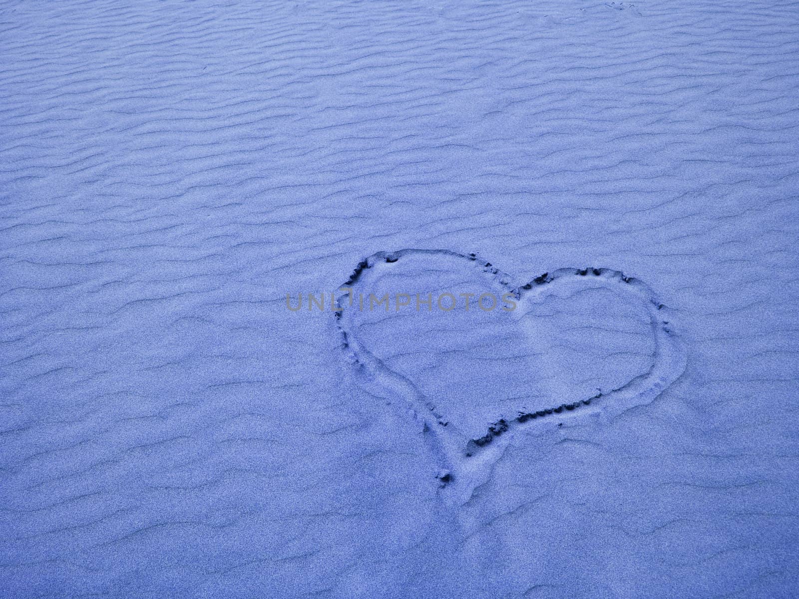 Blue Heart in the Sand on a Sunny Day