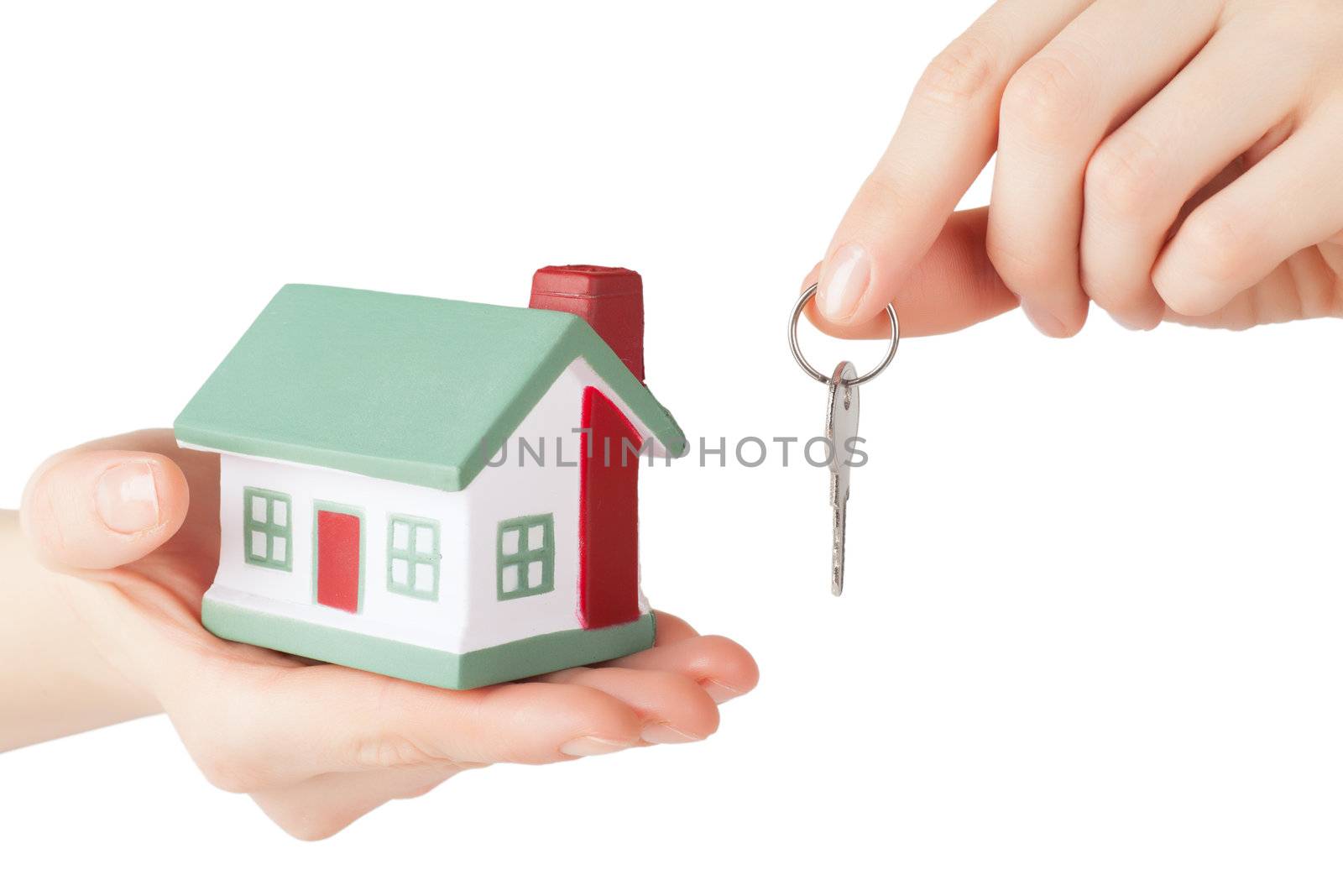 Little house toy and key in hands isolated over white background
