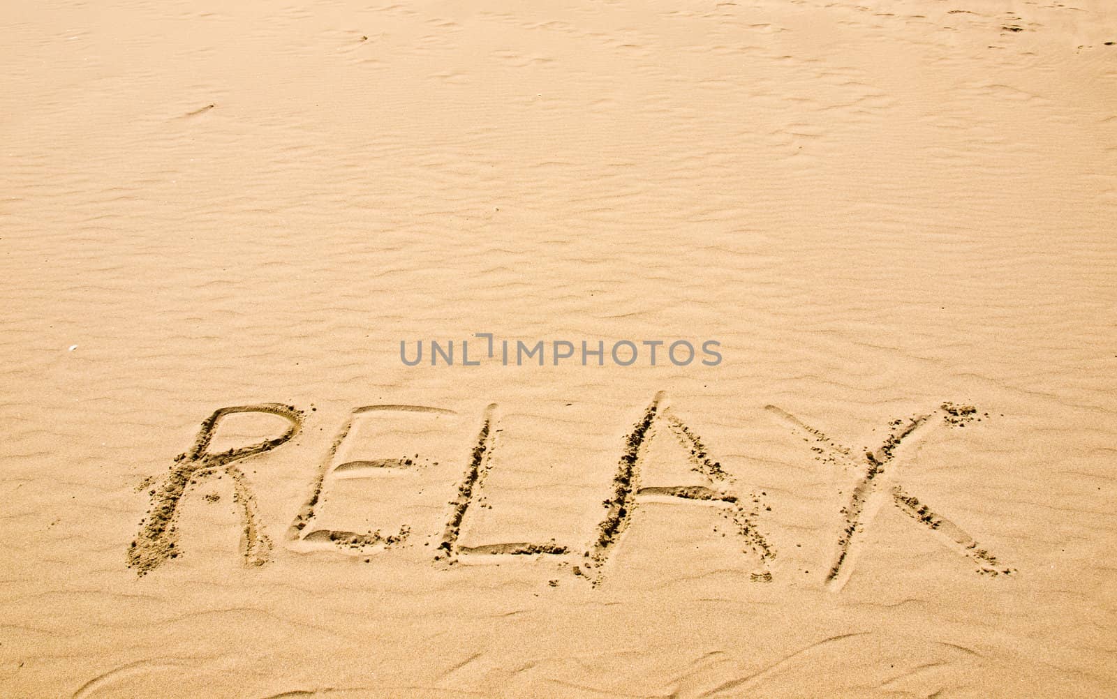 Relax Written in the Sand on a Sunny Day