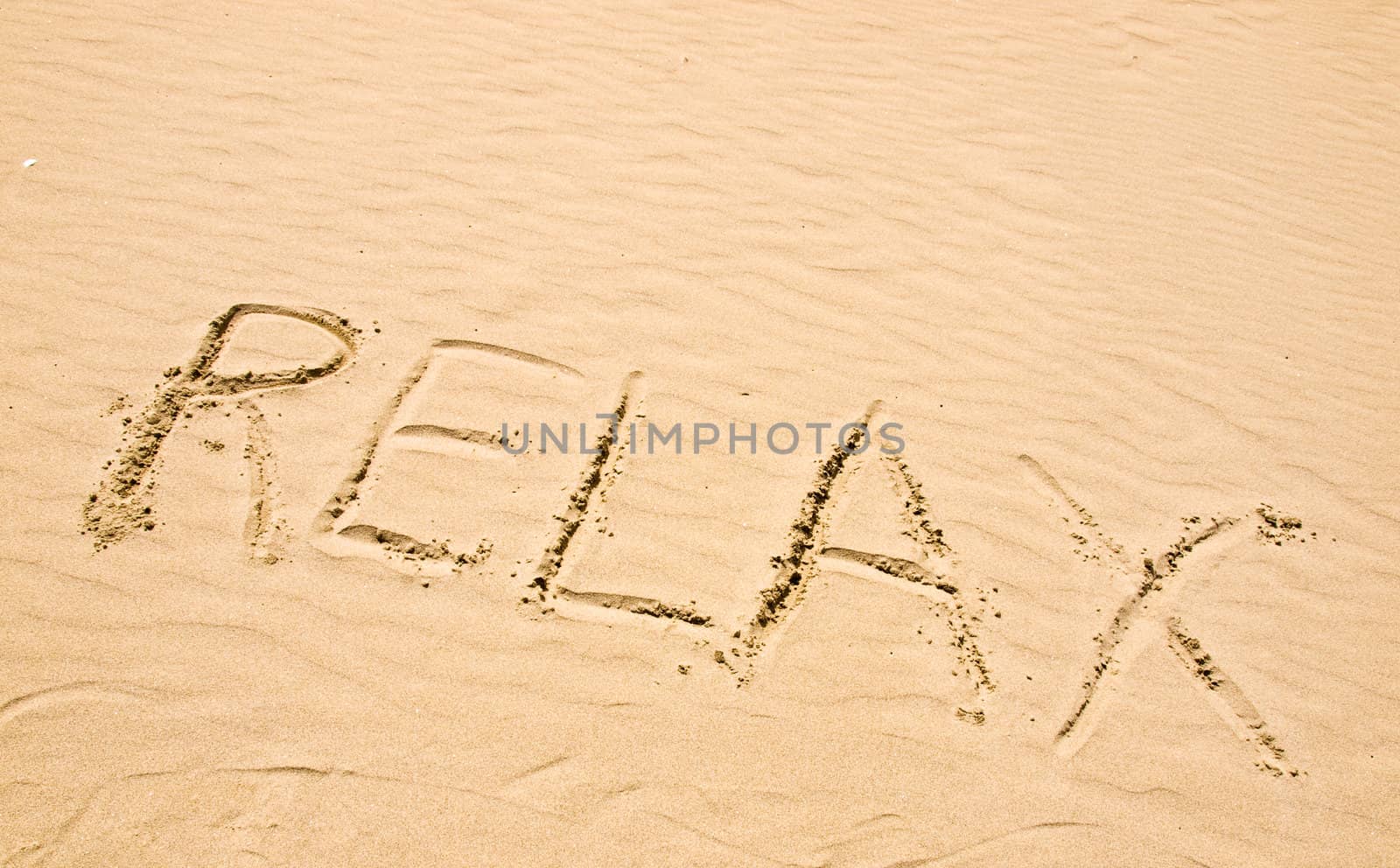 Relax Written in the Sand on a Sunny Day