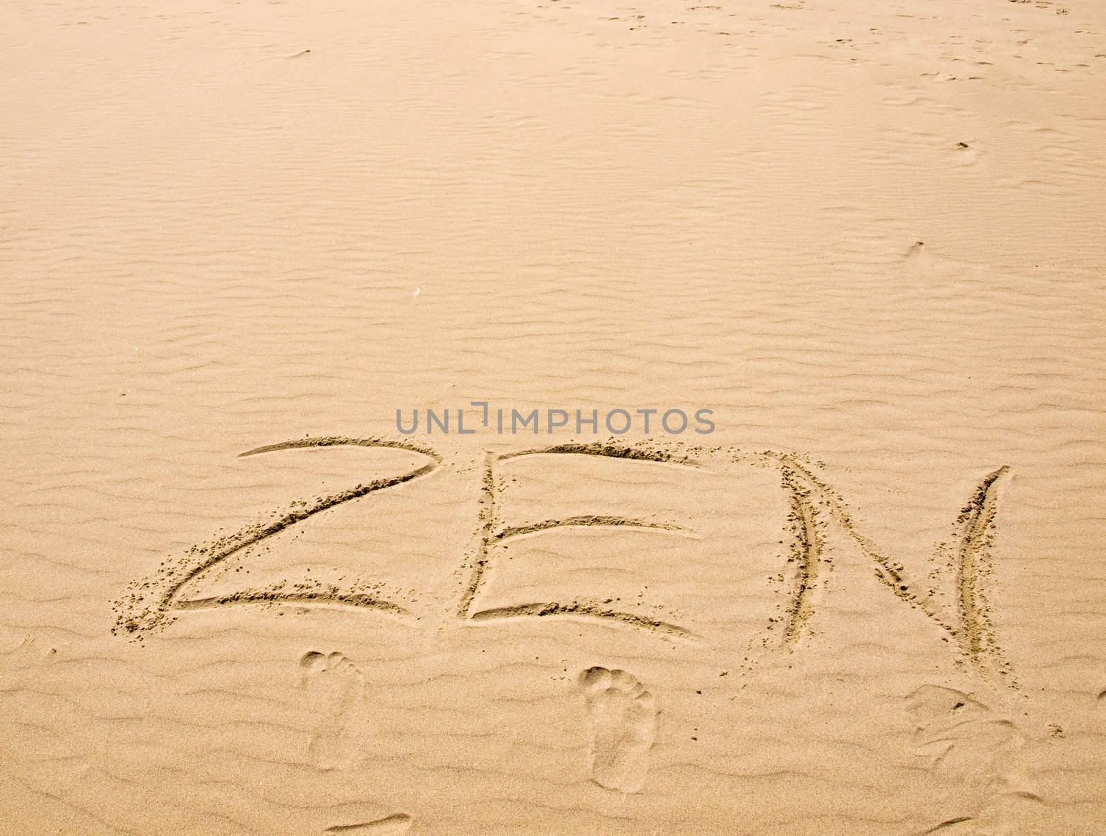 Zen Written in the Sand on a Sunny Day with Footprints