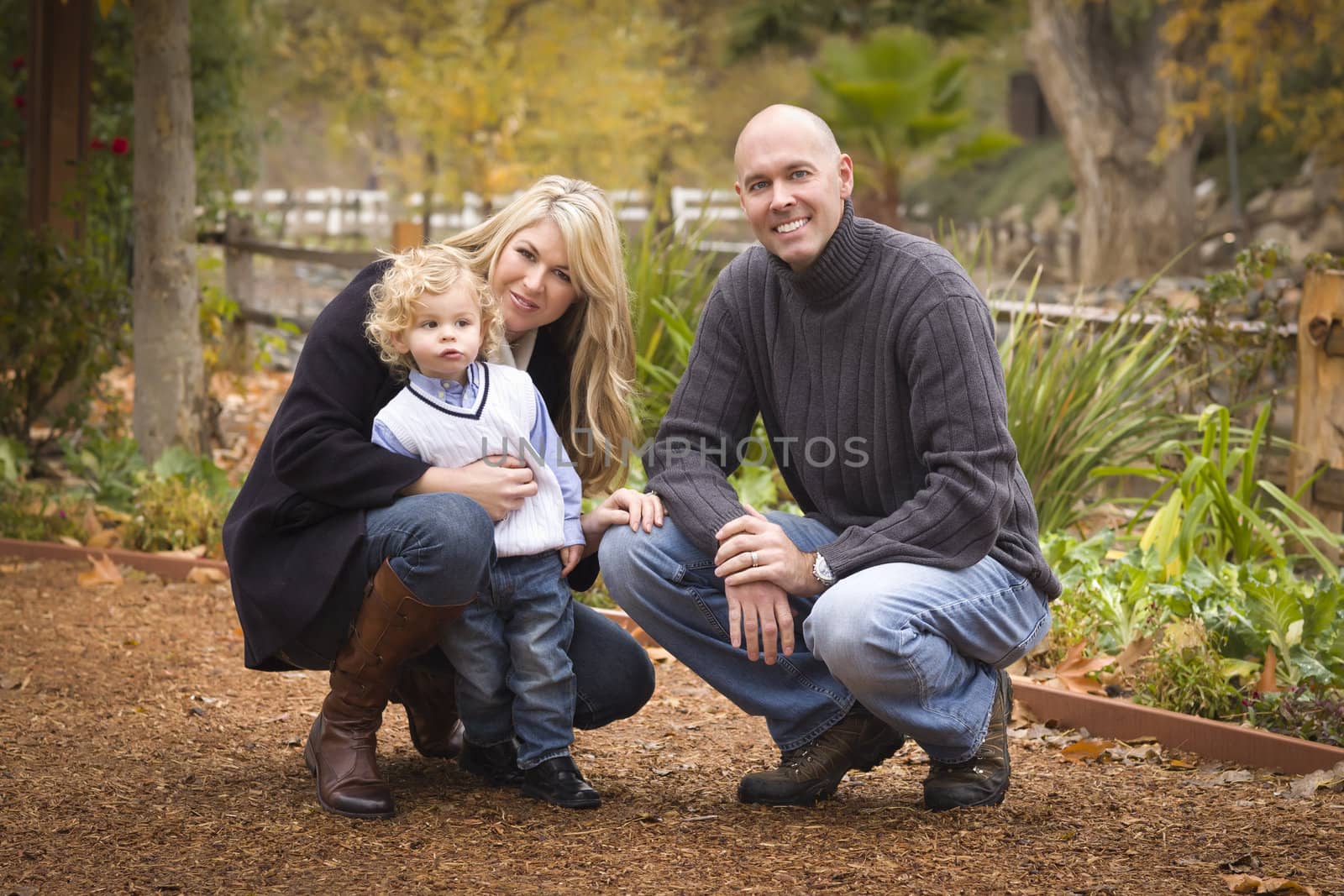 Young Attractive Parents and Child Portrait Outside in the Park.