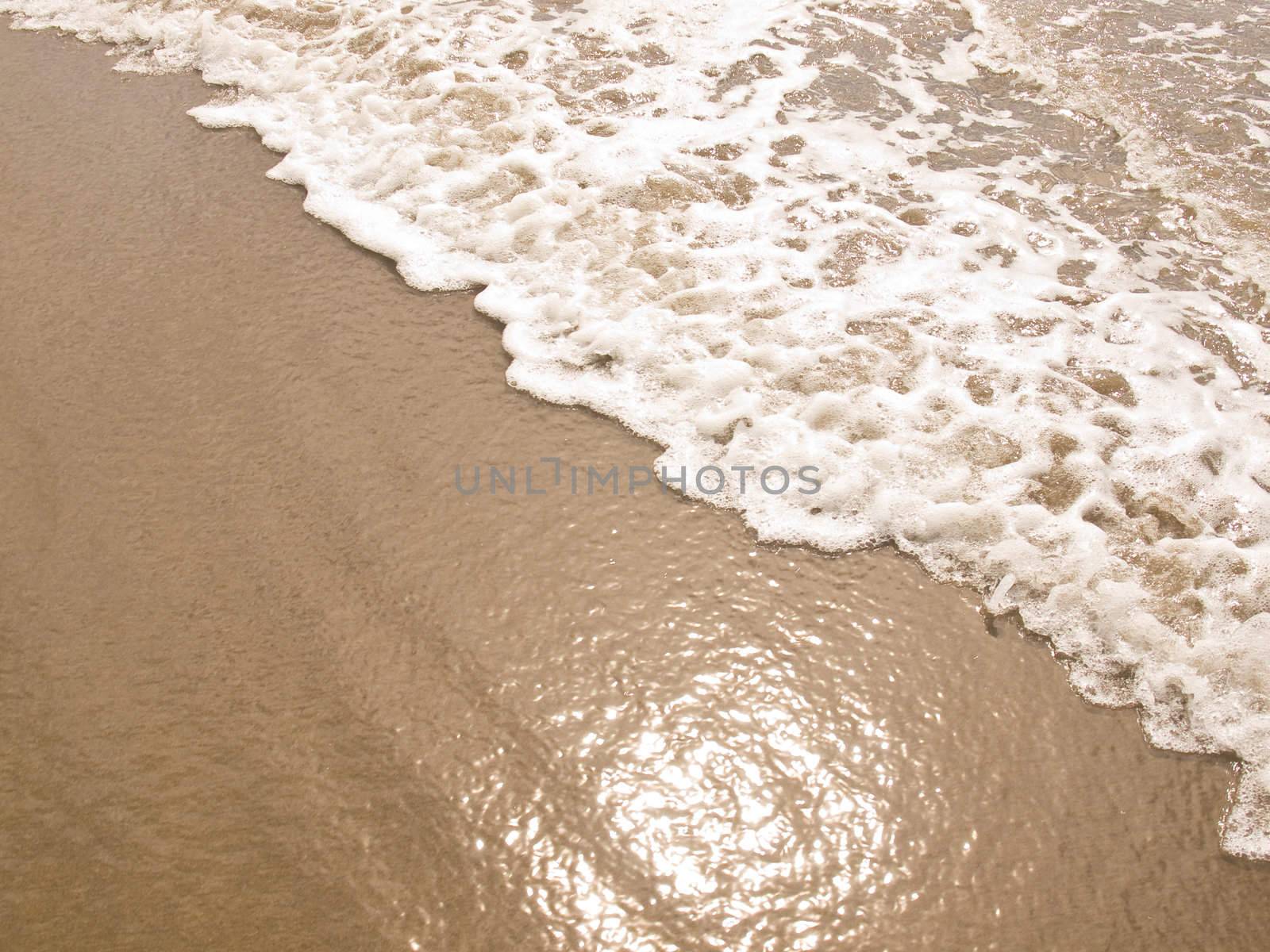 Foamy Ocean Shoreline at a Sunny Beach 