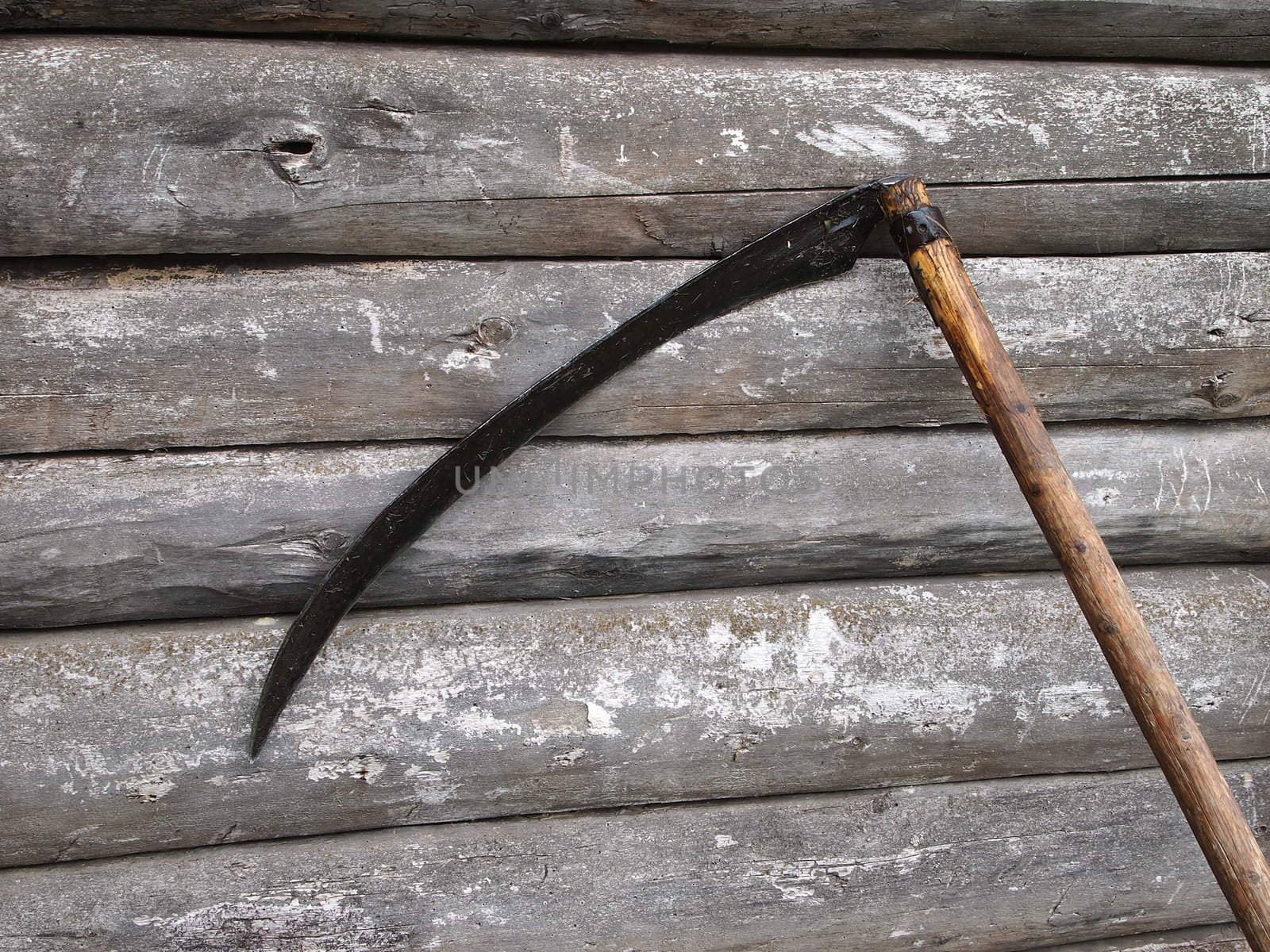 scythe at the old log walls