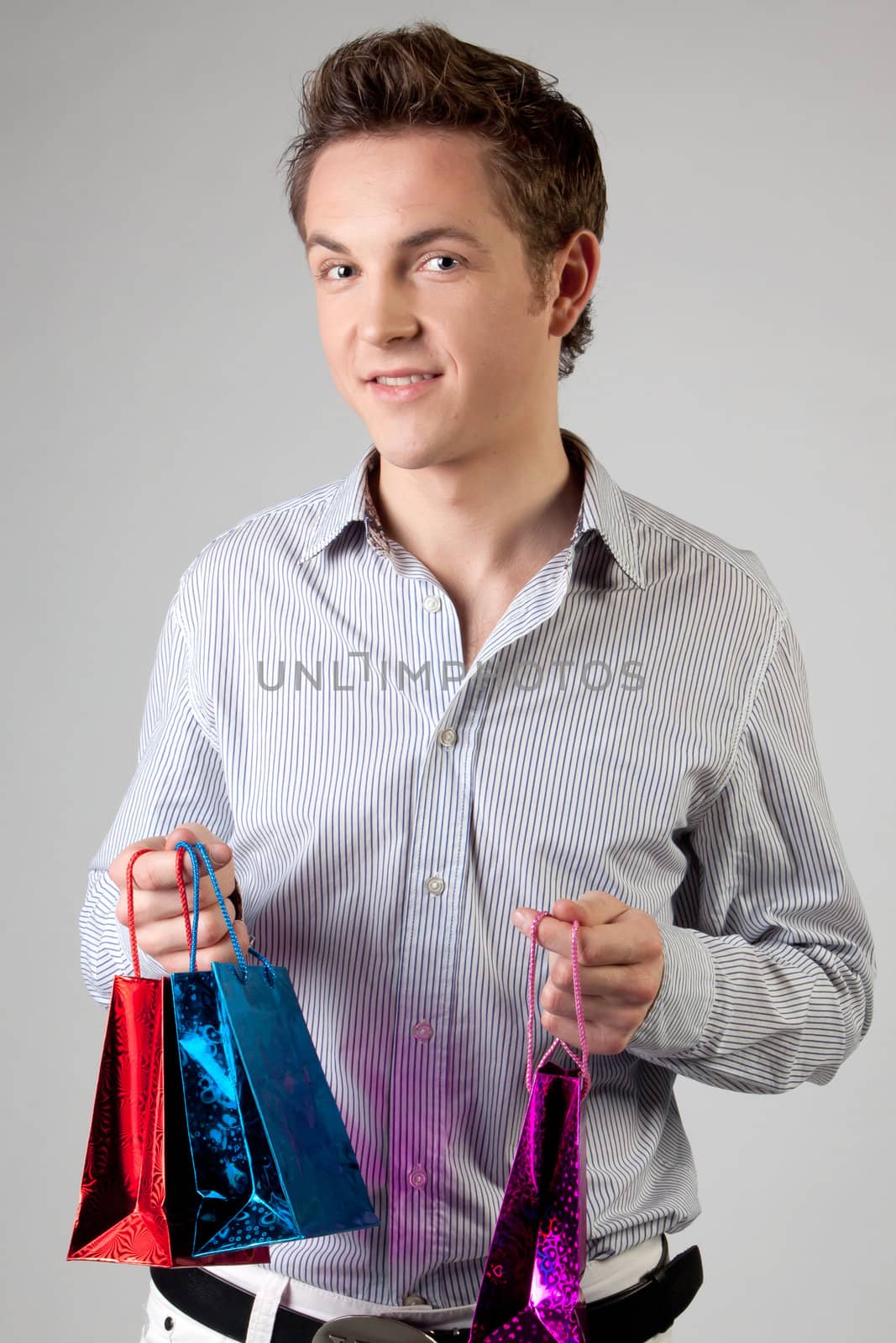 Portrait of a young man in formal attire with a New Year's gifts in their hands