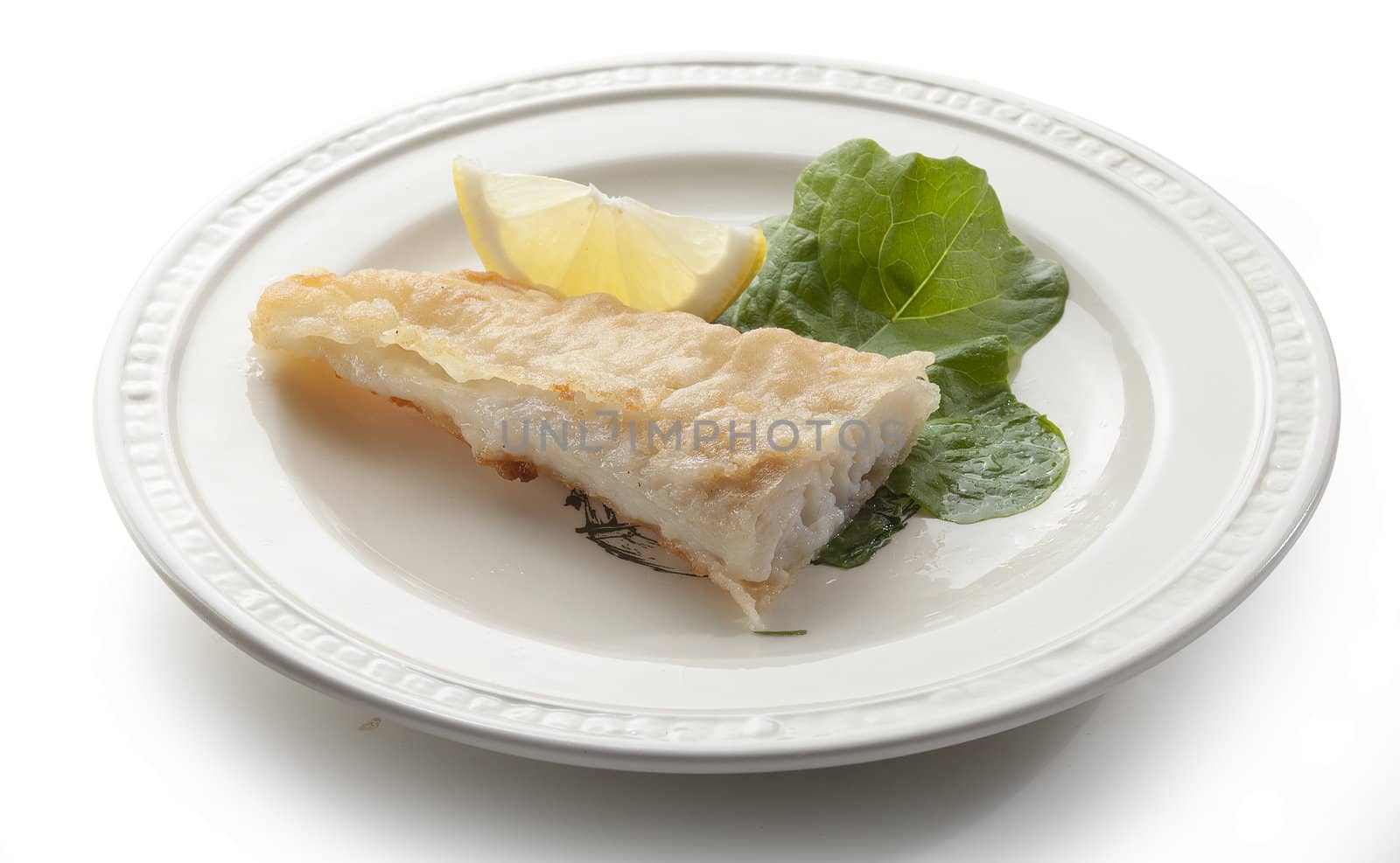 Fried fillet of pangasius with lettuce and lemon on the white plate