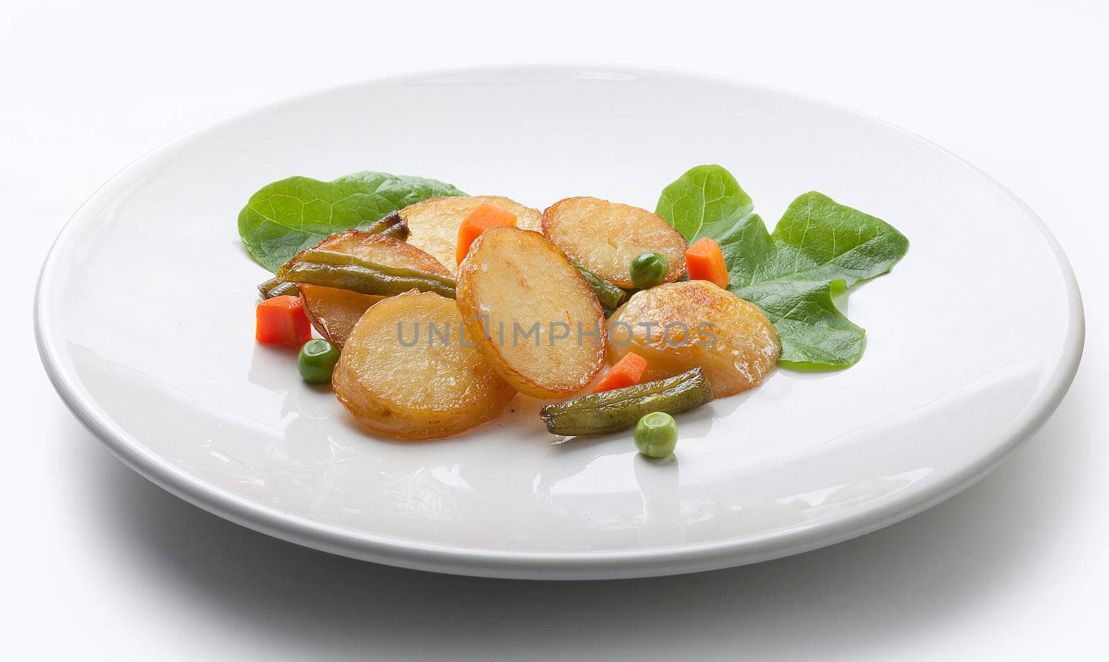 Fried potato with lettuce and vegetables on the white plate