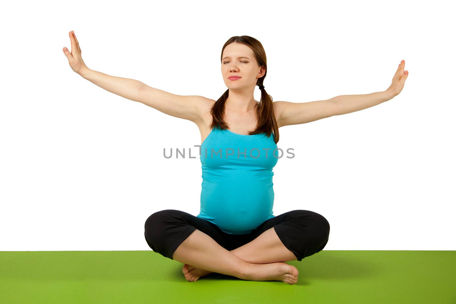 Pregnant young women stretching and exercising on the green yoga mat. 37 weeks.